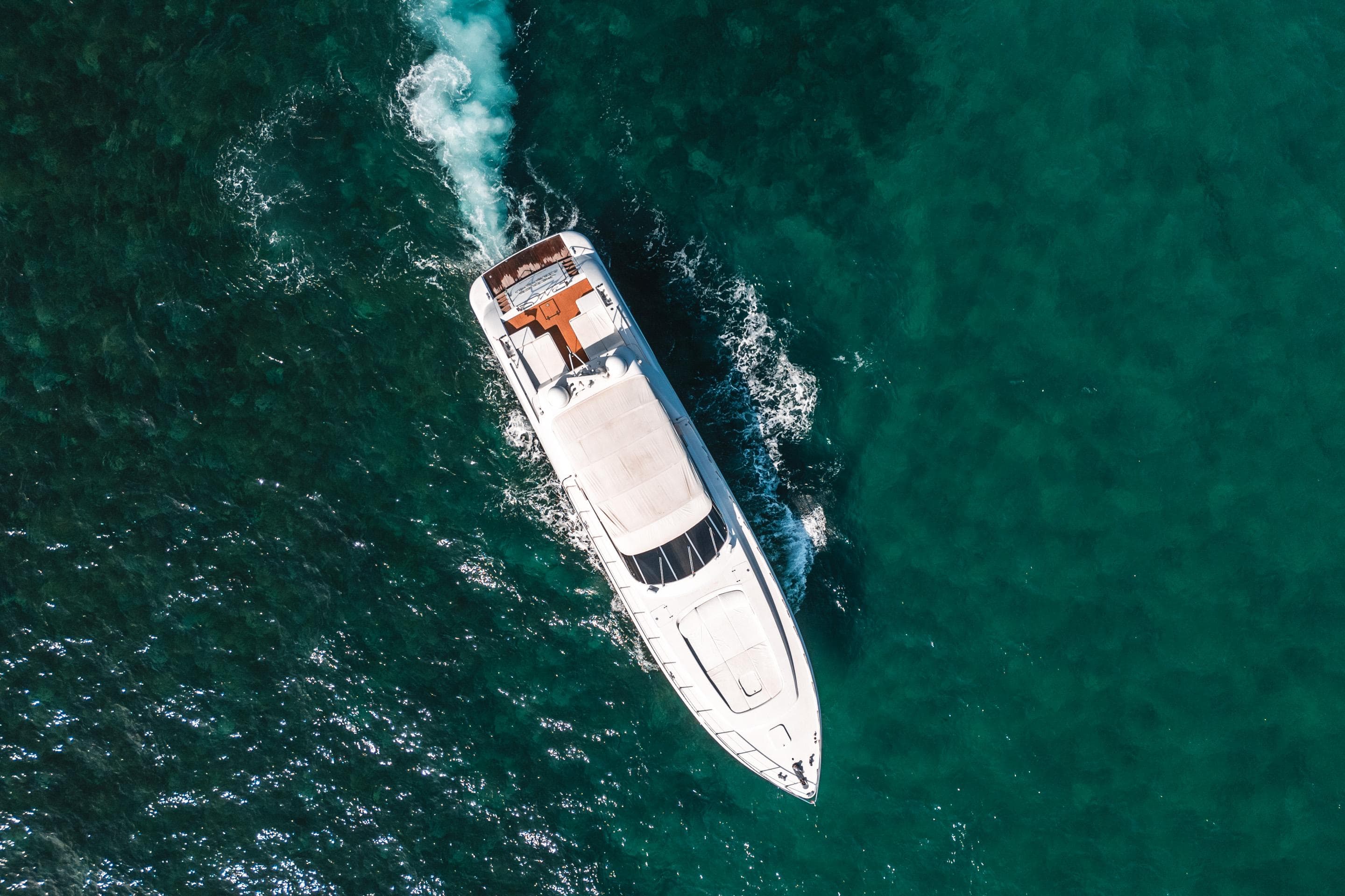 Aerial view of 2001 Mangusta 80 yacht cruising on turquoise water.
