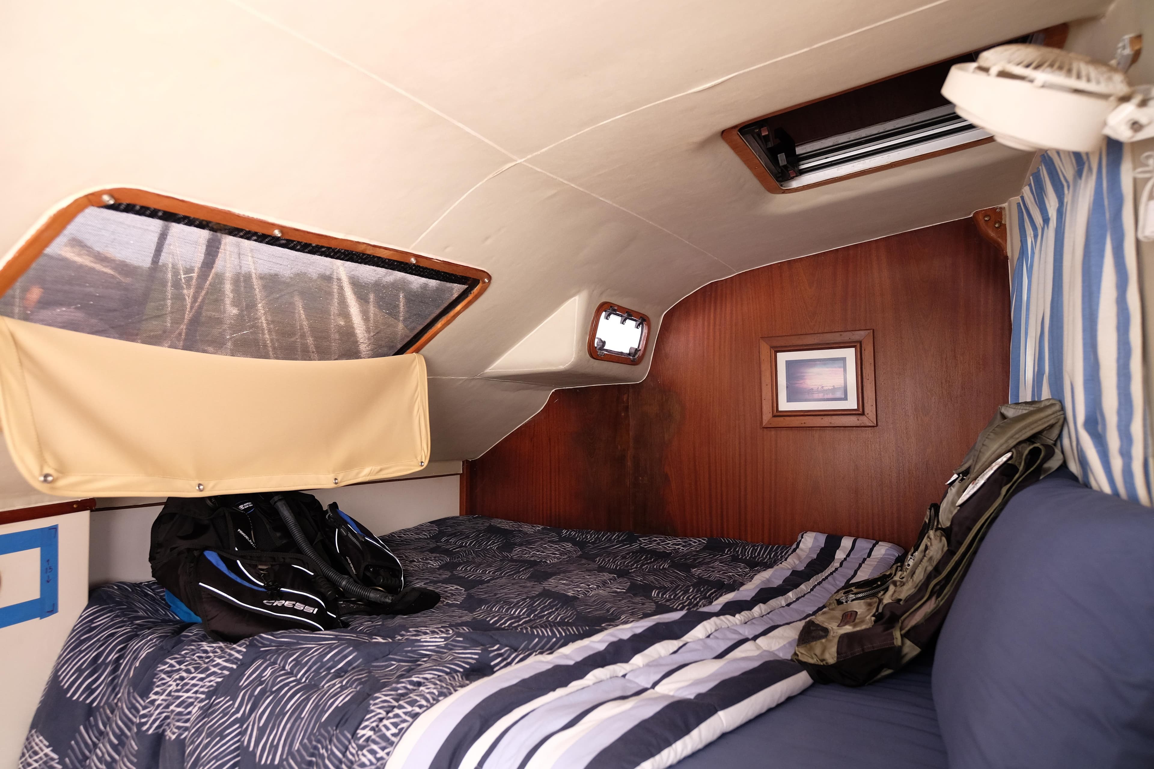 Cozy cabin interior of 1996 Simpson Inspiration boat with bed and gear.