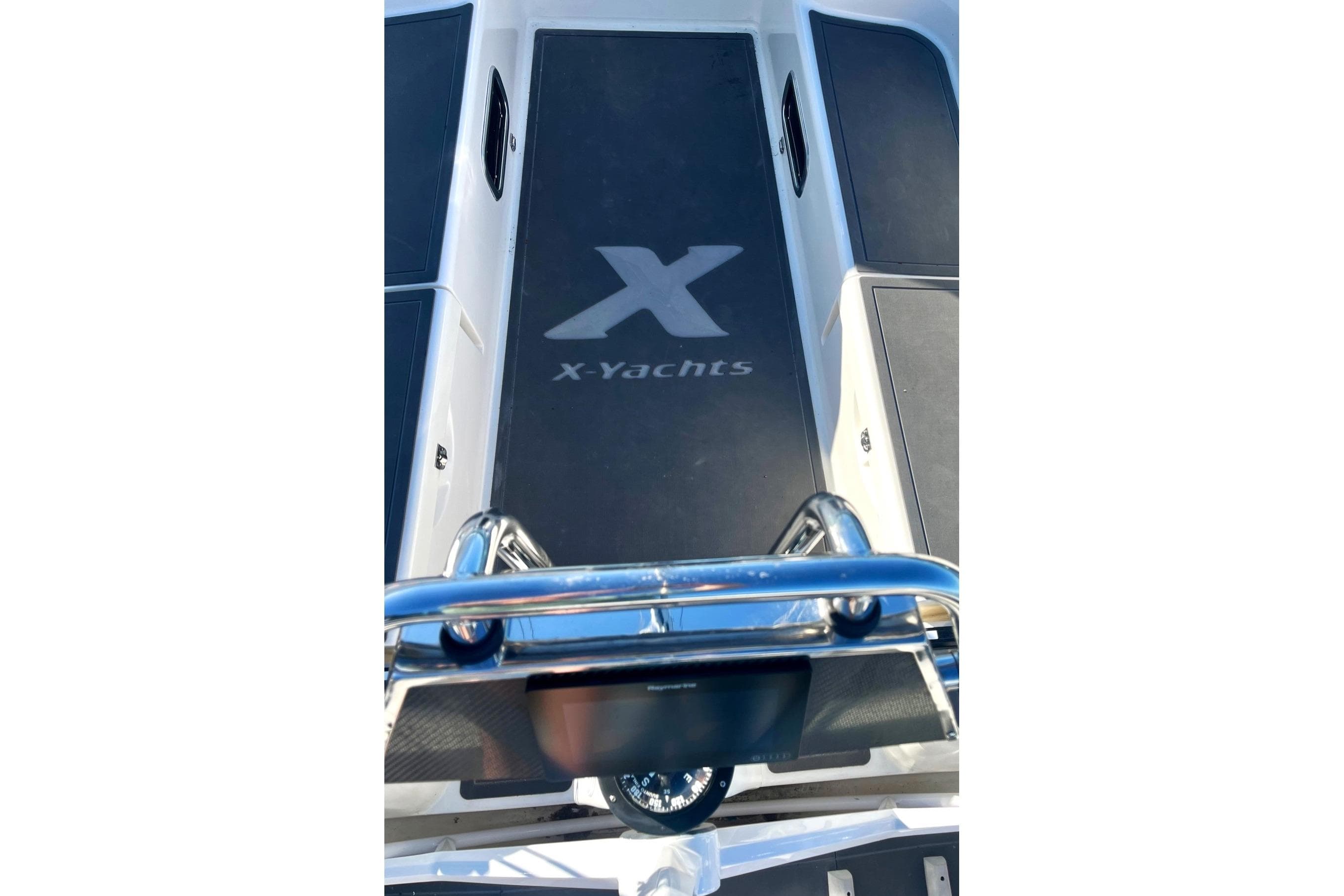 2004 X-Yachts X-46 deck with logo, featuring sleek design and polished metal railing.