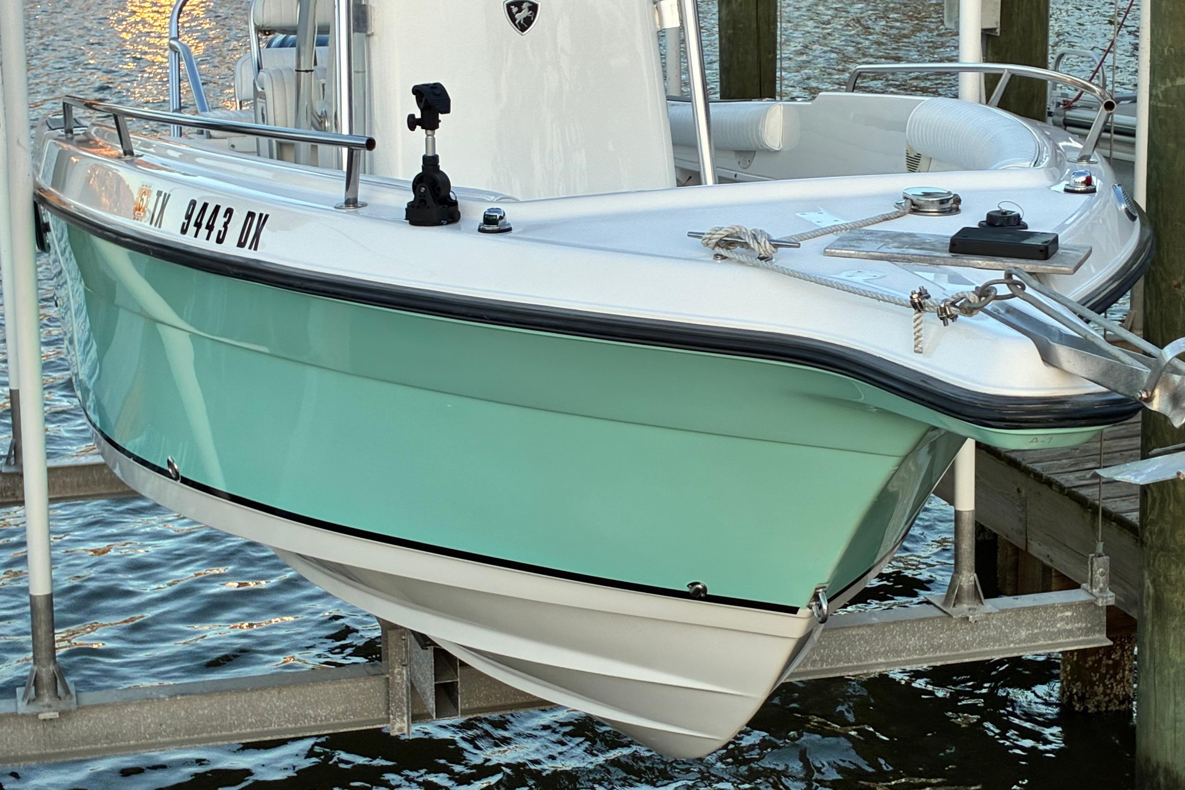 2004 Century 2200 Center Console boat docked, featuring a sleek turquoise hull.