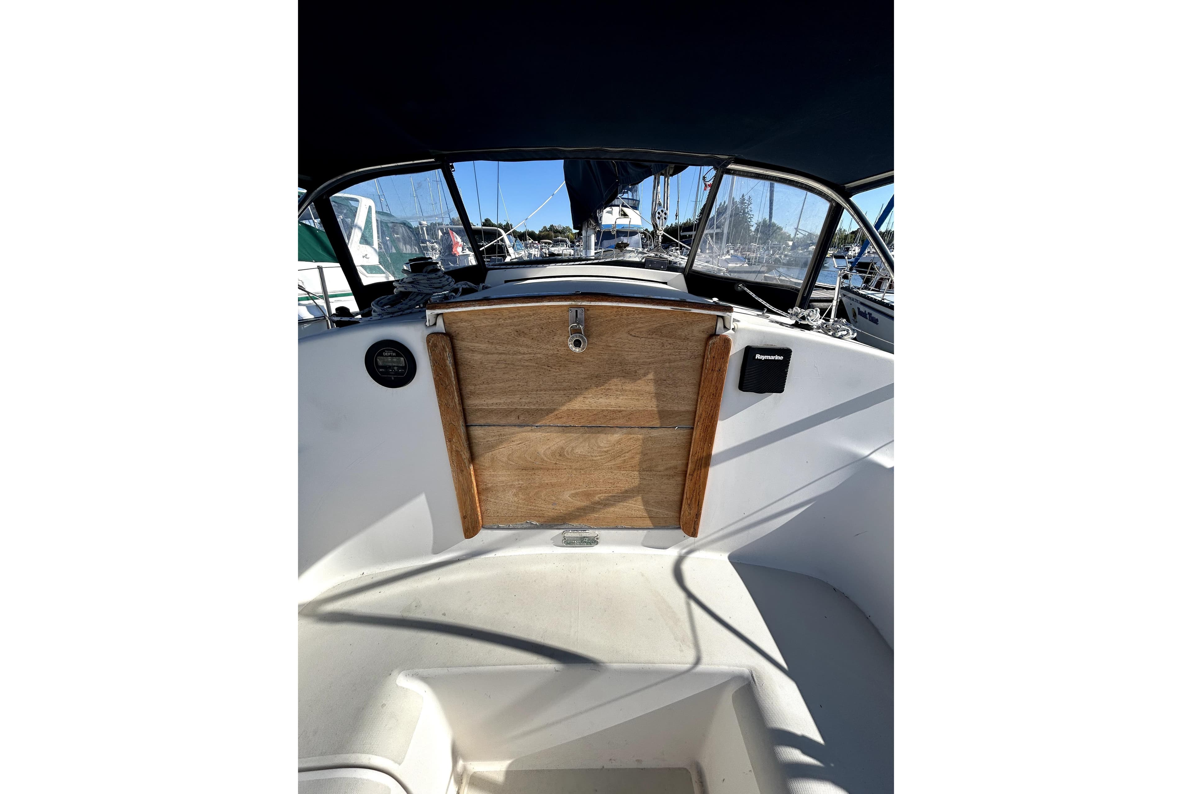 Cockpit of 1983 Pearson 34 sailboat with wooden hatch and navigational equipment.
