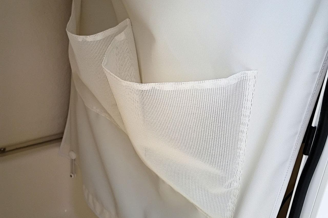 White mesh storage pockets on a shower curtain in a Pioneer 202 Islander, 2027 model.