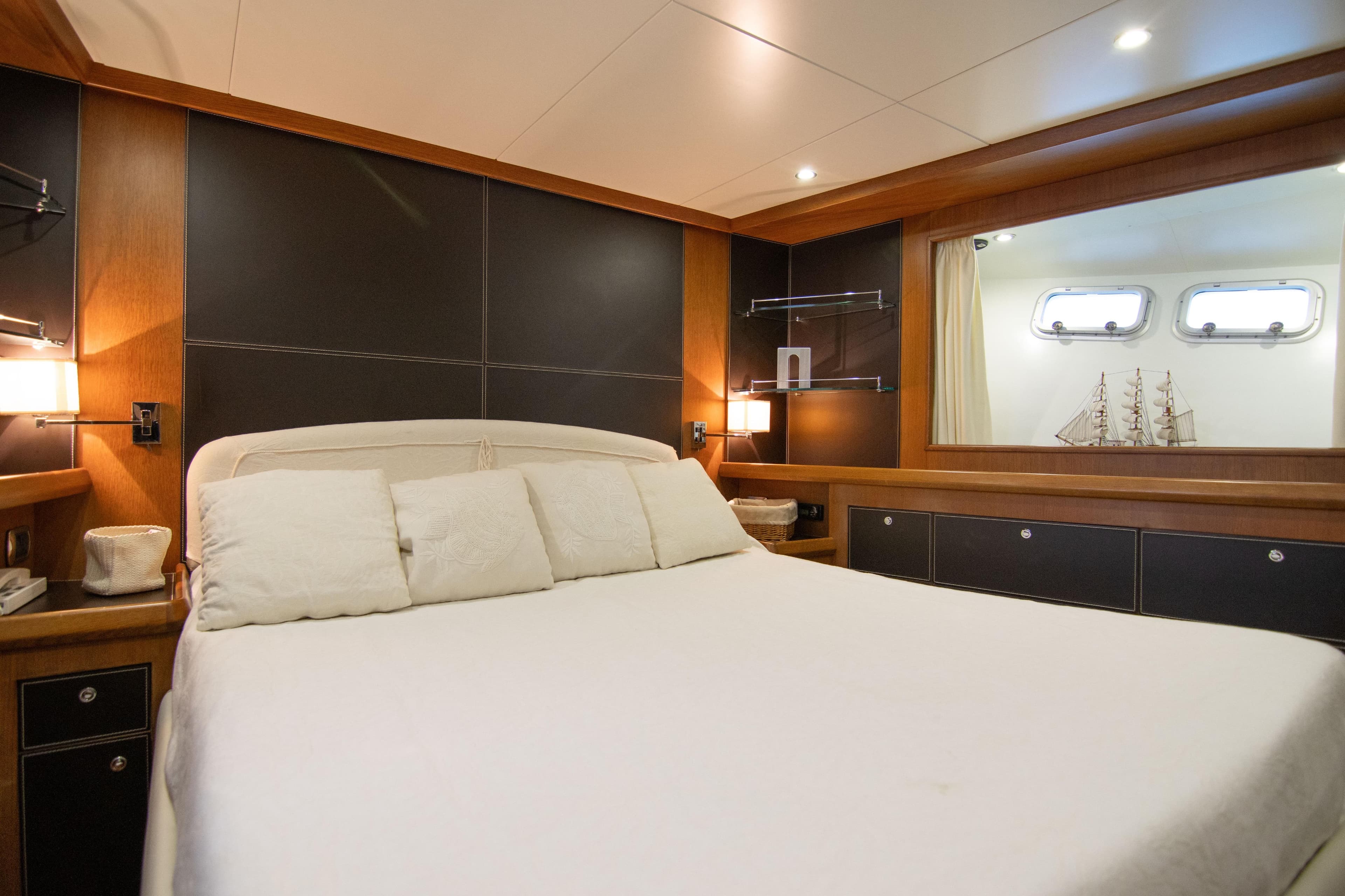 Luxurious bedroom interior of 2000 Bugari NAVETTA yacht with elegant wood paneling and soft lighting.