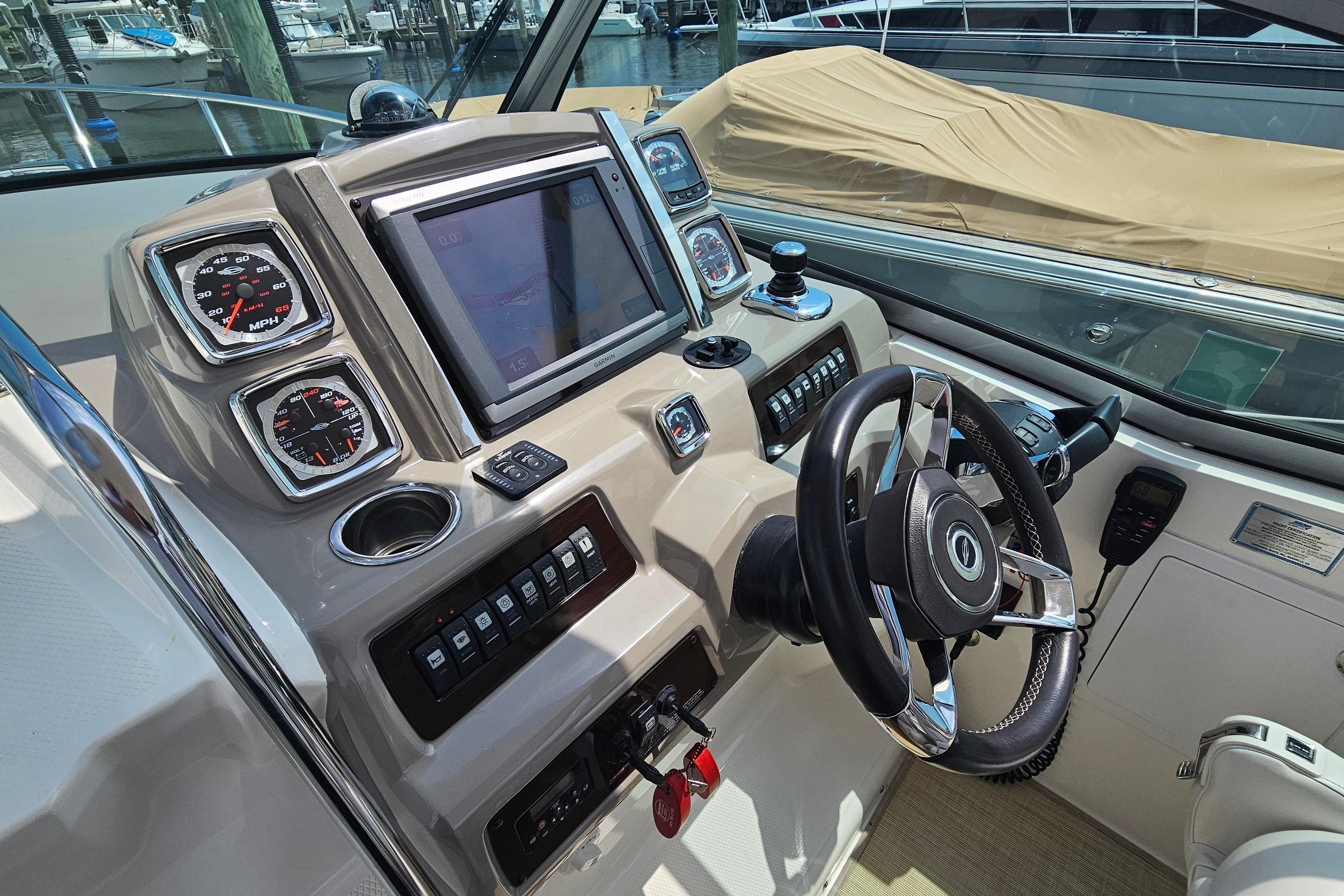 Control panel of a 2015 Chaparral 310 Signature boat with steering wheel and gauges.