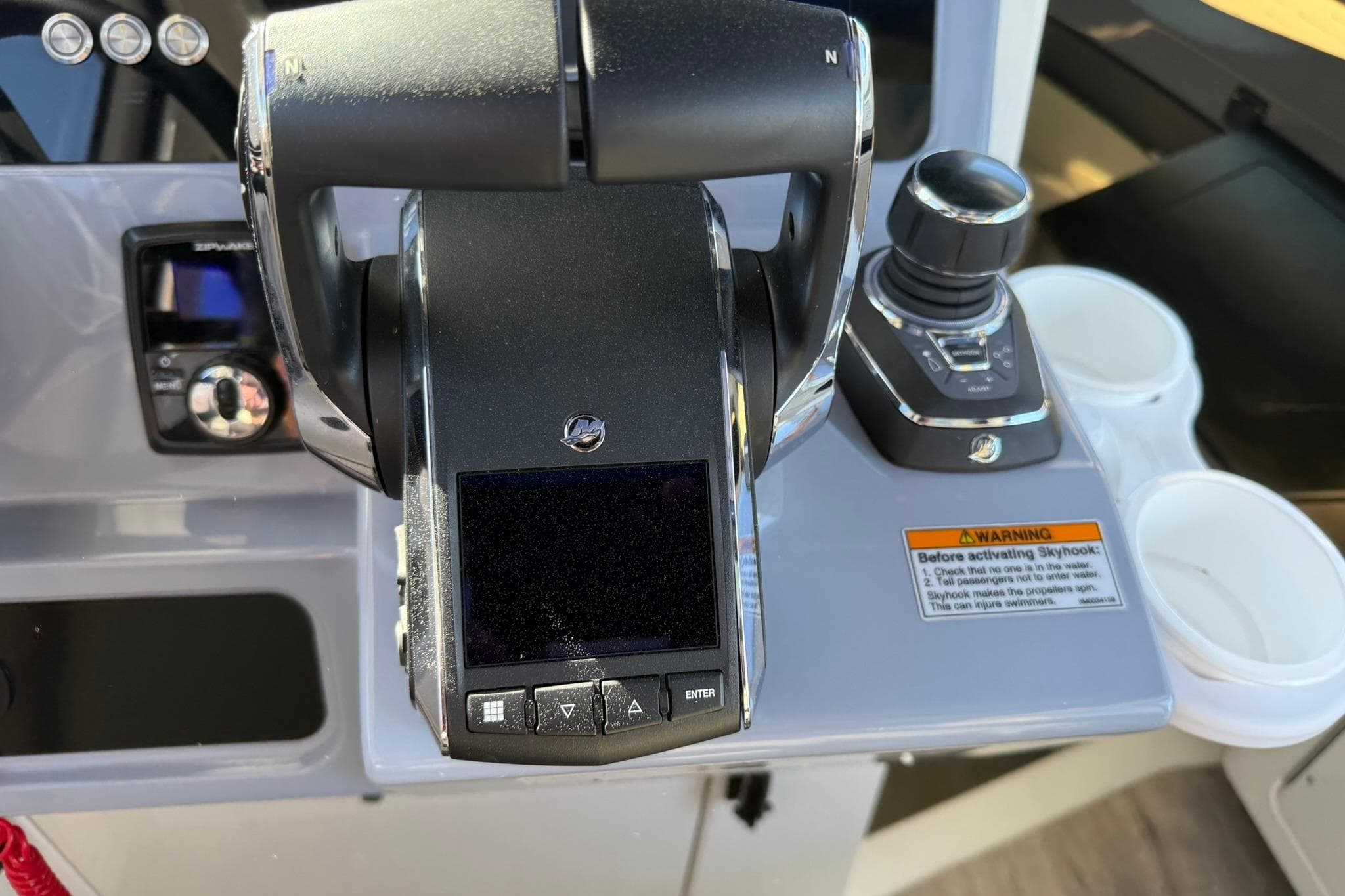 Control panel of 2025 Navan C30 boat with joystick and warning label.