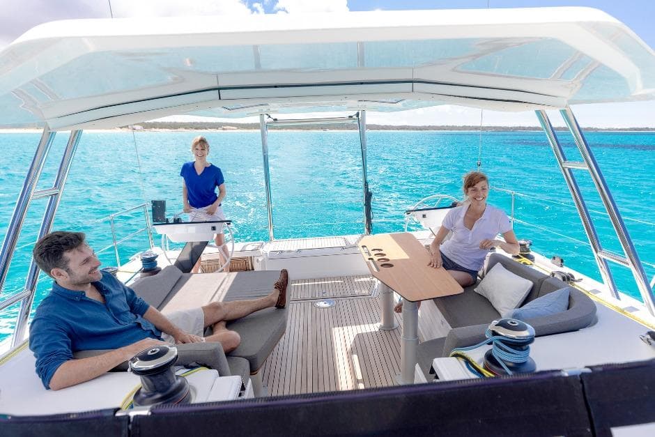 People relaxing on a 2026 Dufour 48 yacht, enjoying the ocean view.