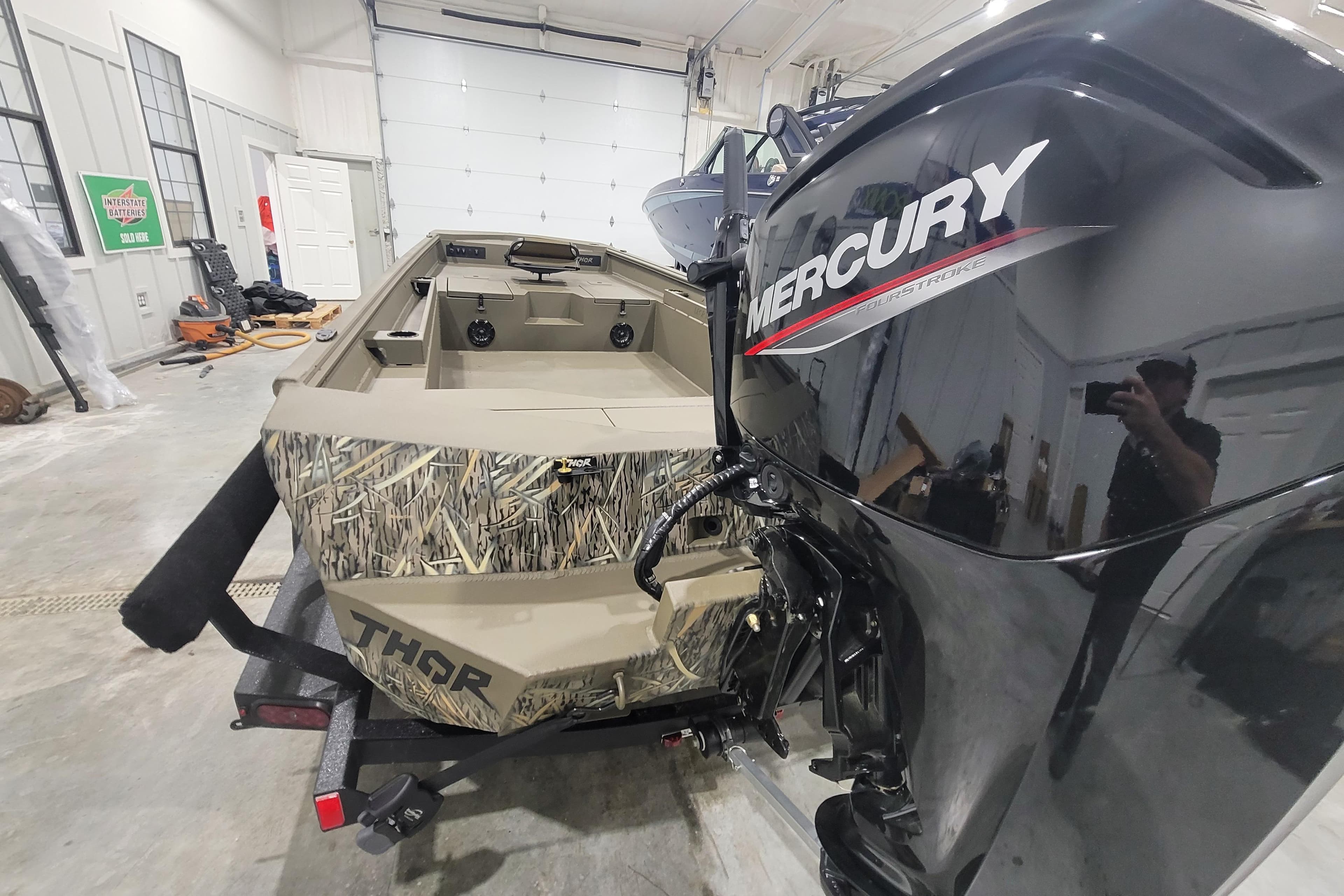 2026 Thor 1860 Timber Hammer Elite boat with Mercury engine in a garage.