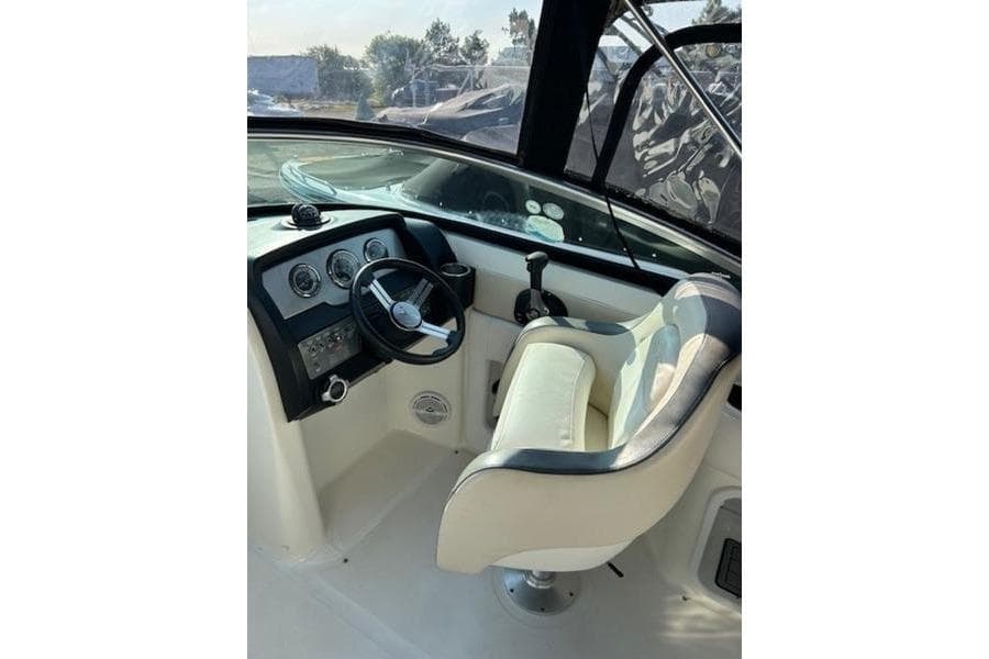 Interior view of 2012 Sea Ray 220 Sundeck boat cockpit with steering wheel and captain's chair.