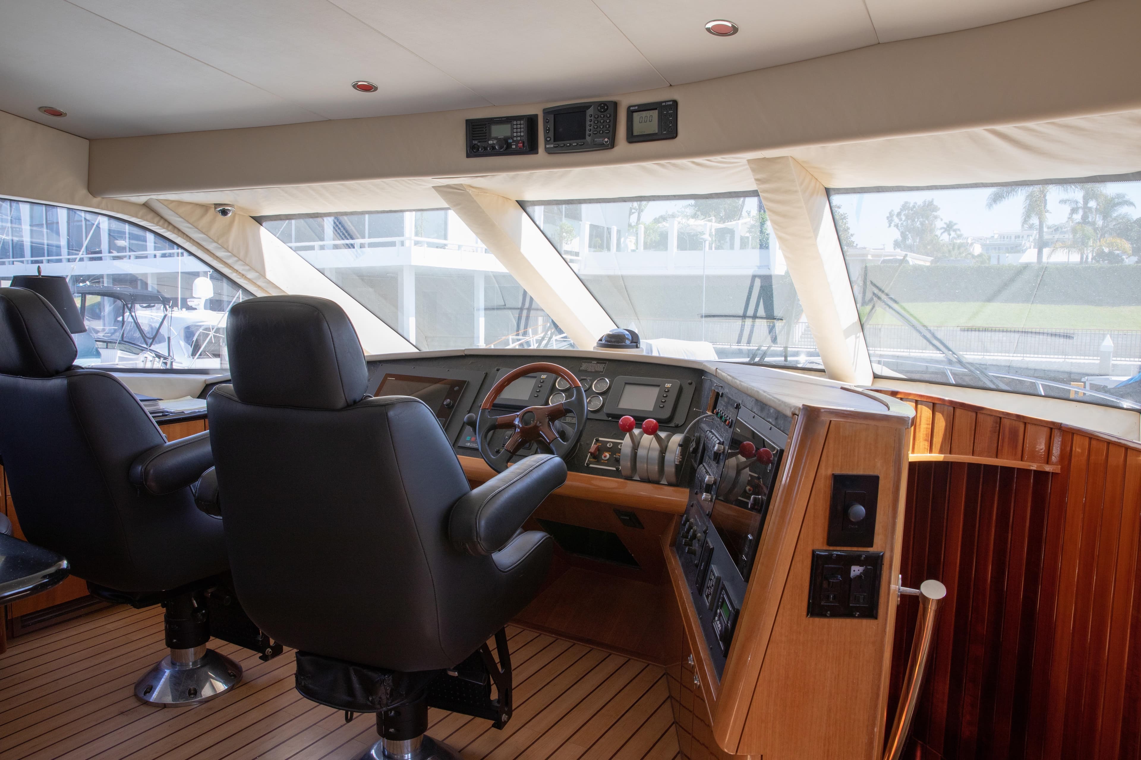 Interior of 2002 Hatteras 63 Raised Pilothouse Motor Yacht cockpit with leather seats and control panel.