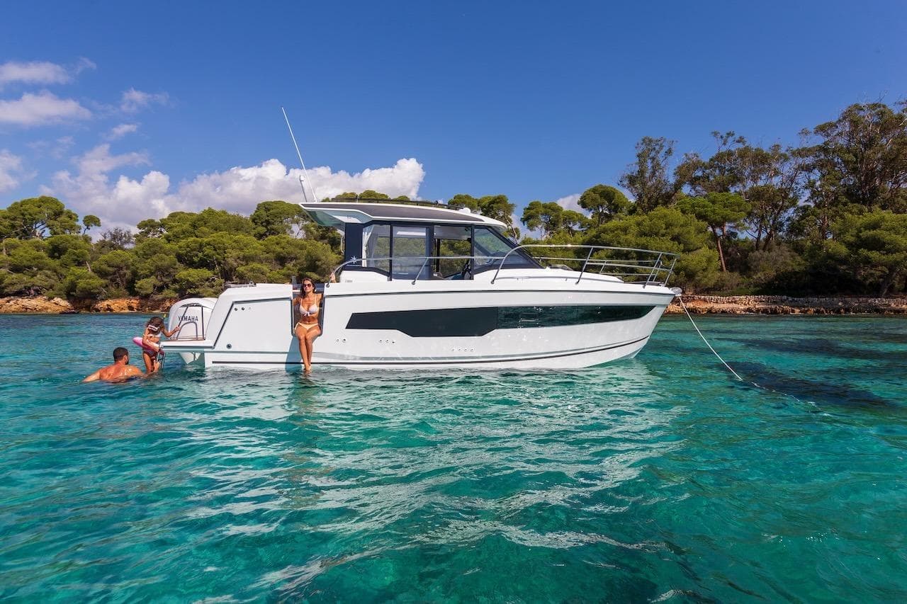 2025 Jeanneau NC 895 Series 2 yacht in clear turquoise water, with people enjoying the sun.