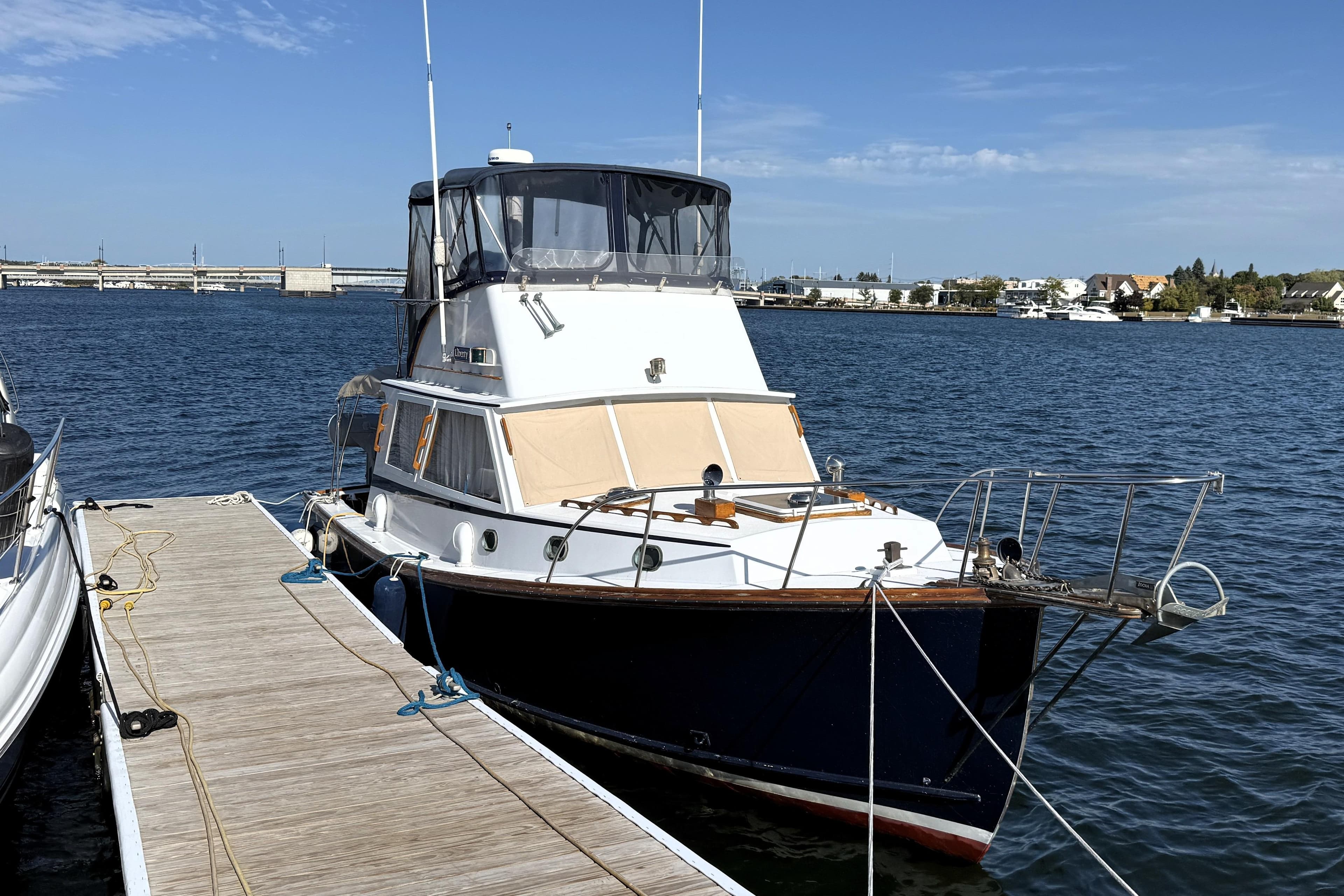 1983 Wilbur 34 Fly Bridge Cruiser docked at marina on a sunny day.