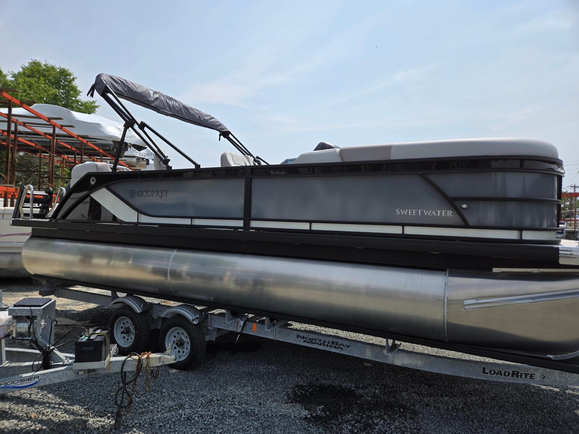 2026 Godfrey Sweetwater 2286 QS pontoon boat on trailer, outdoor setting.