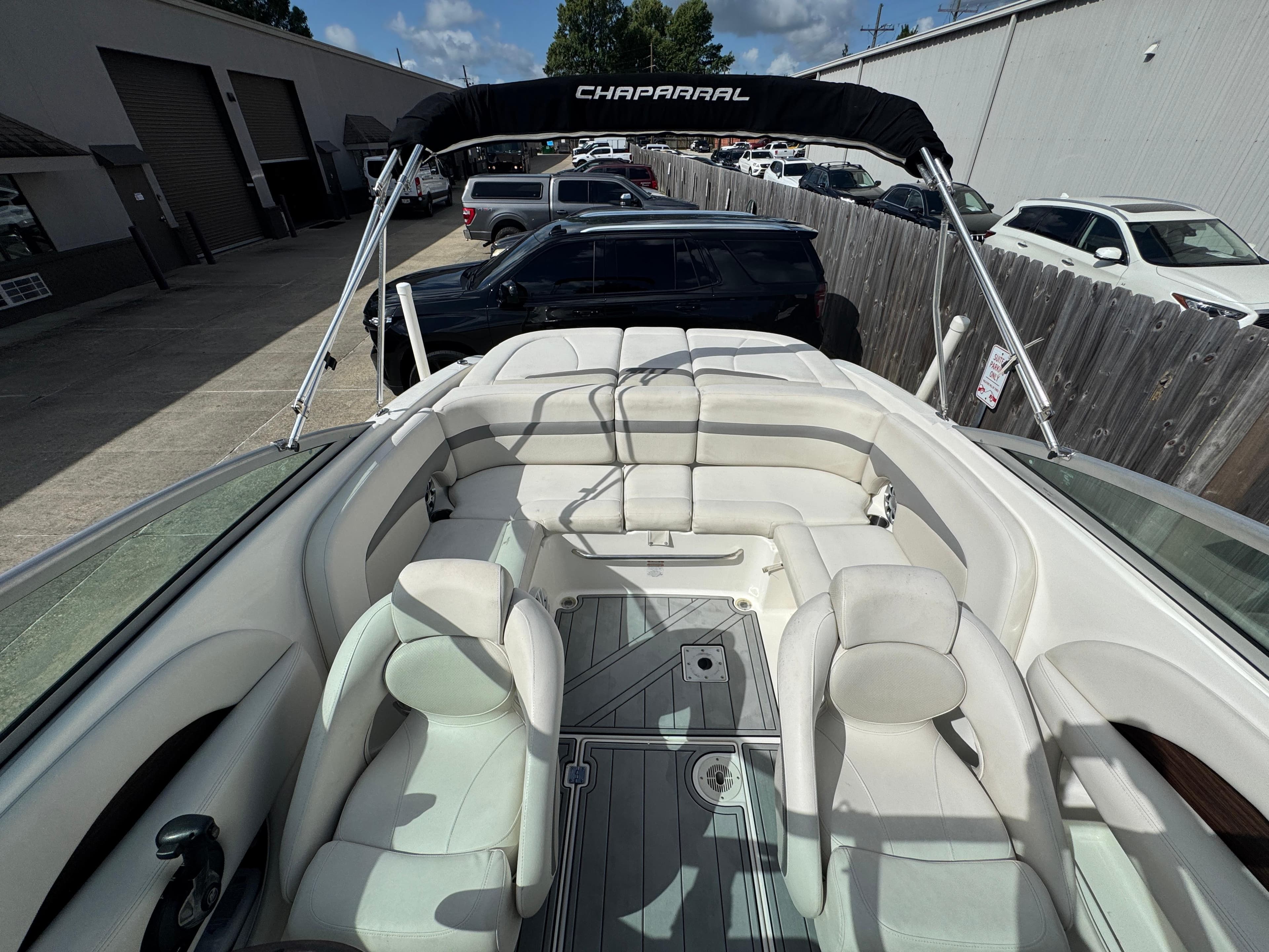 2006 Chaparral 236 SSi boat interior with white seating and bimini top, parked outdoors.
