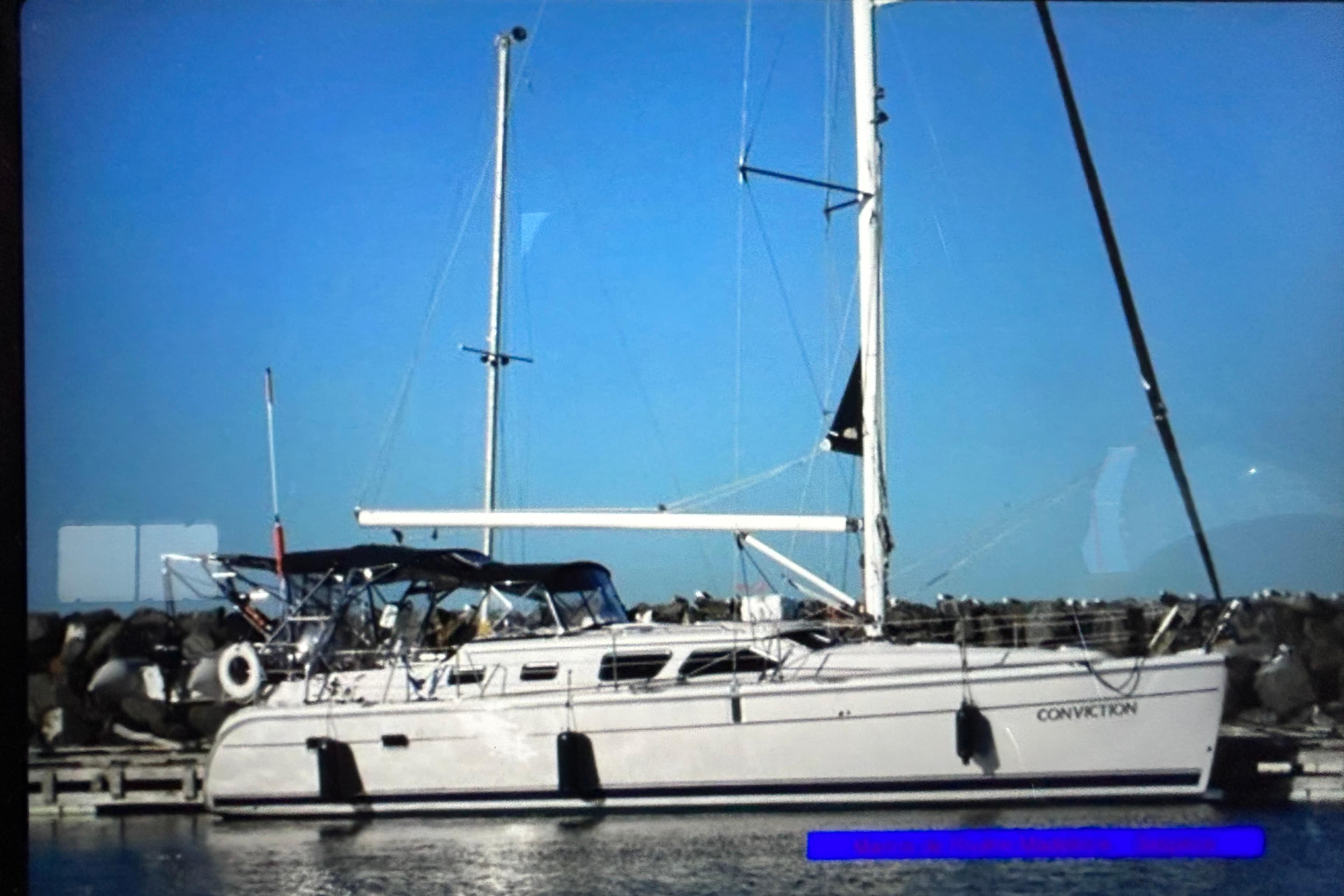 Sailboat docked at marina, 2012 Hunter 41 Deck Salon, clear blue sky background.