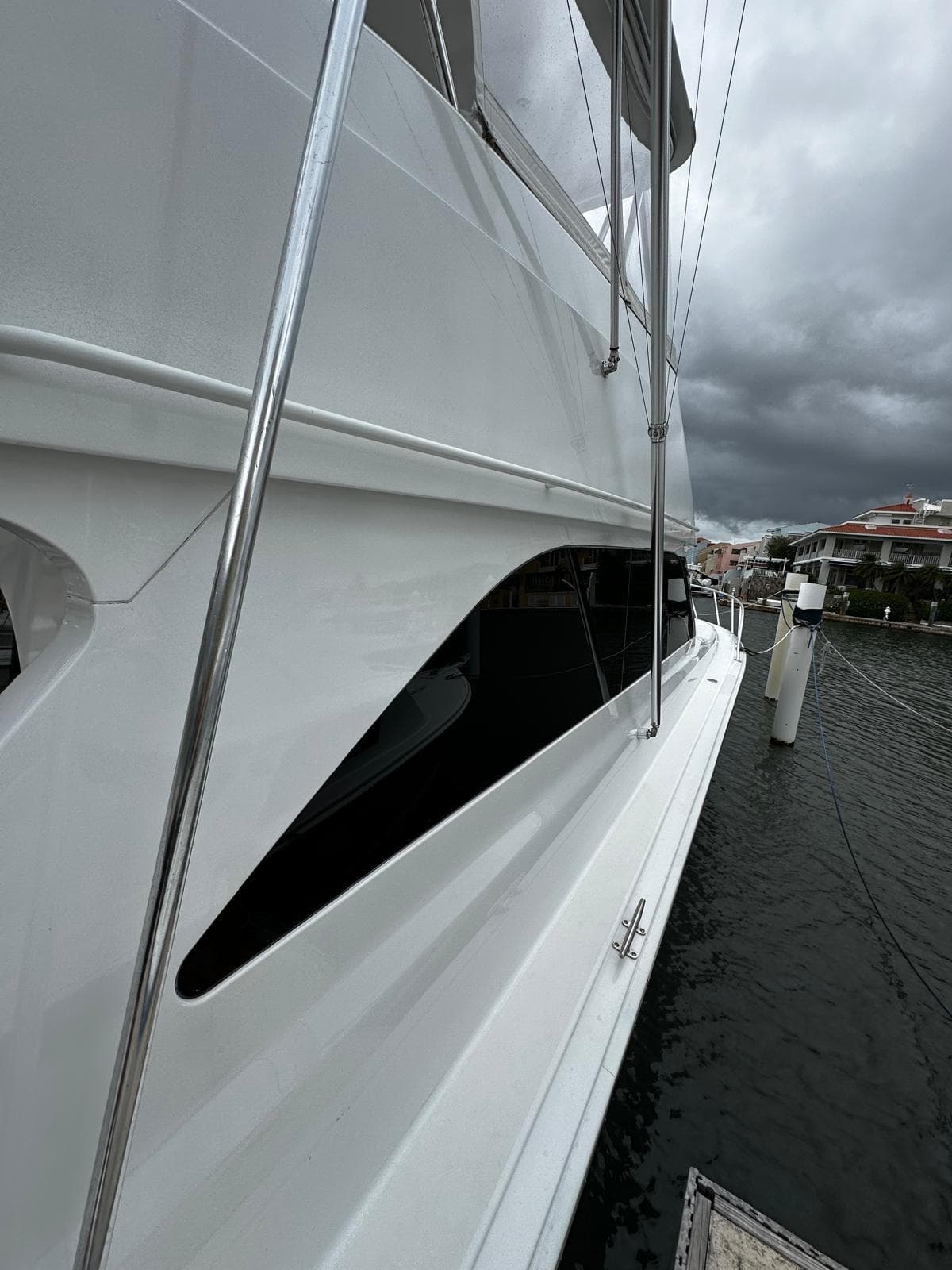 2003 Viking 52 yacht docked, sleek white exterior, overcast sky.