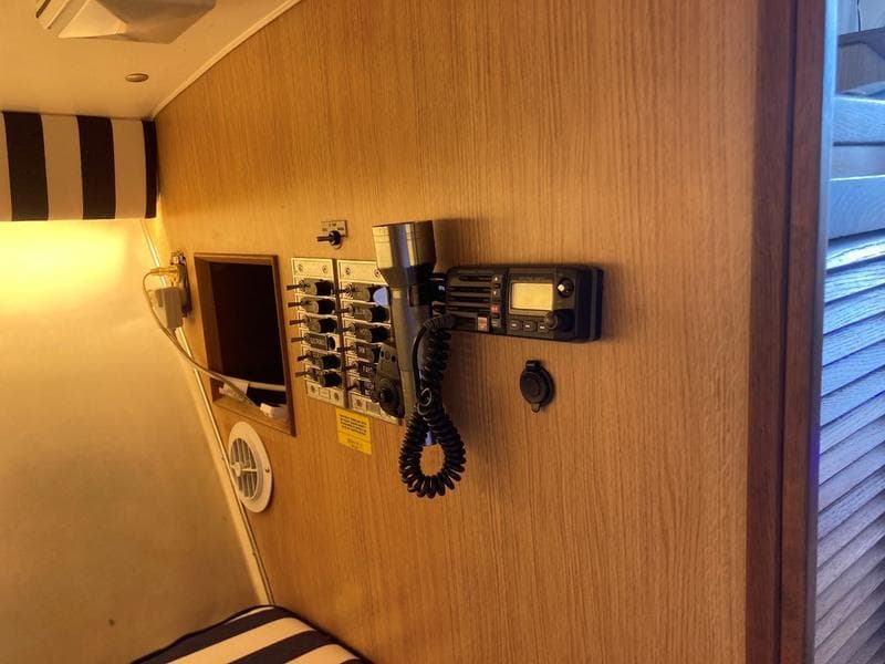 Control panel and radio equipment inside a 1987 Bertram 28 Sport Fisherman boat.