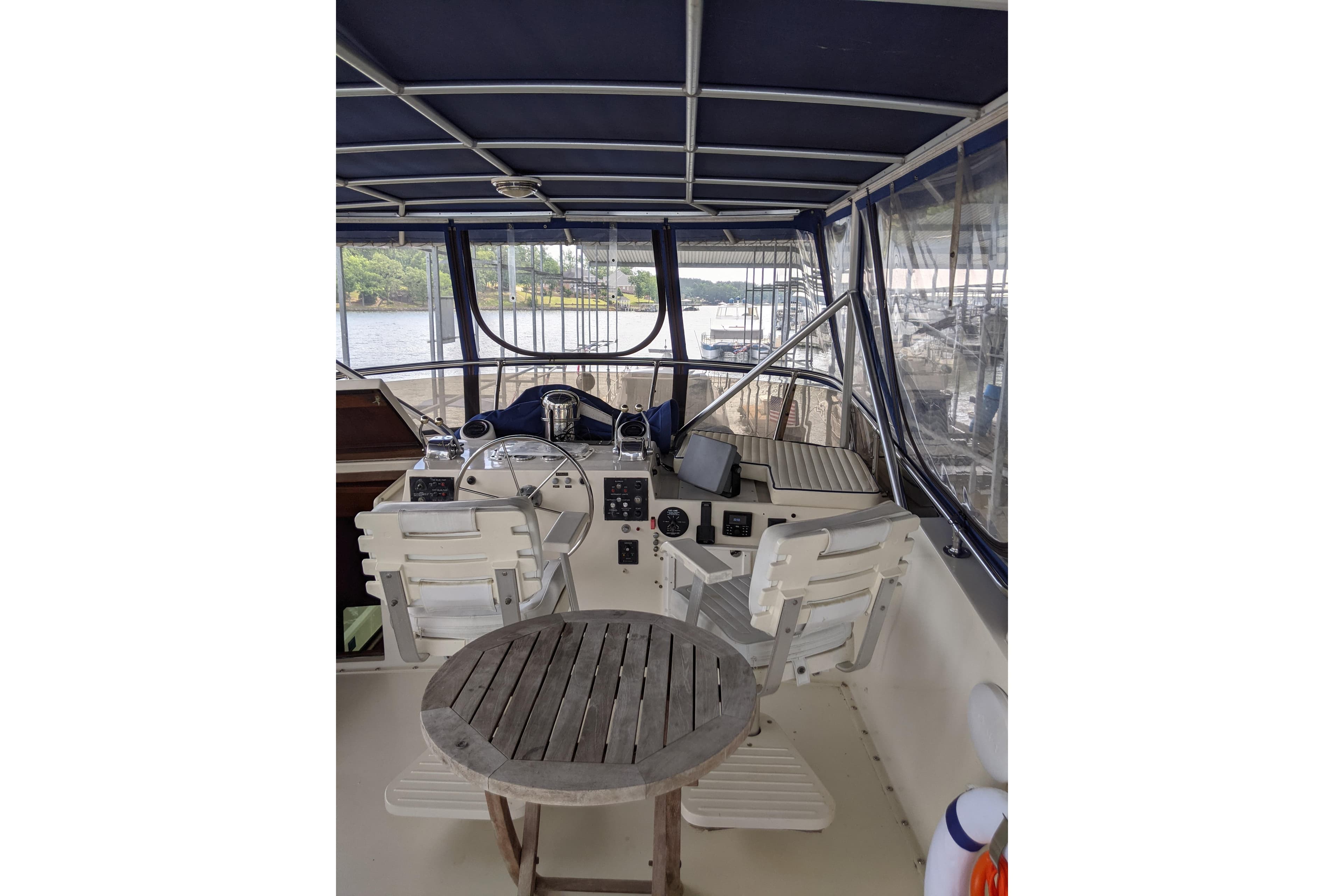 1984 Hatteras 53 Extended Deckhouse Motor Yacht helm with seating and wooden table.