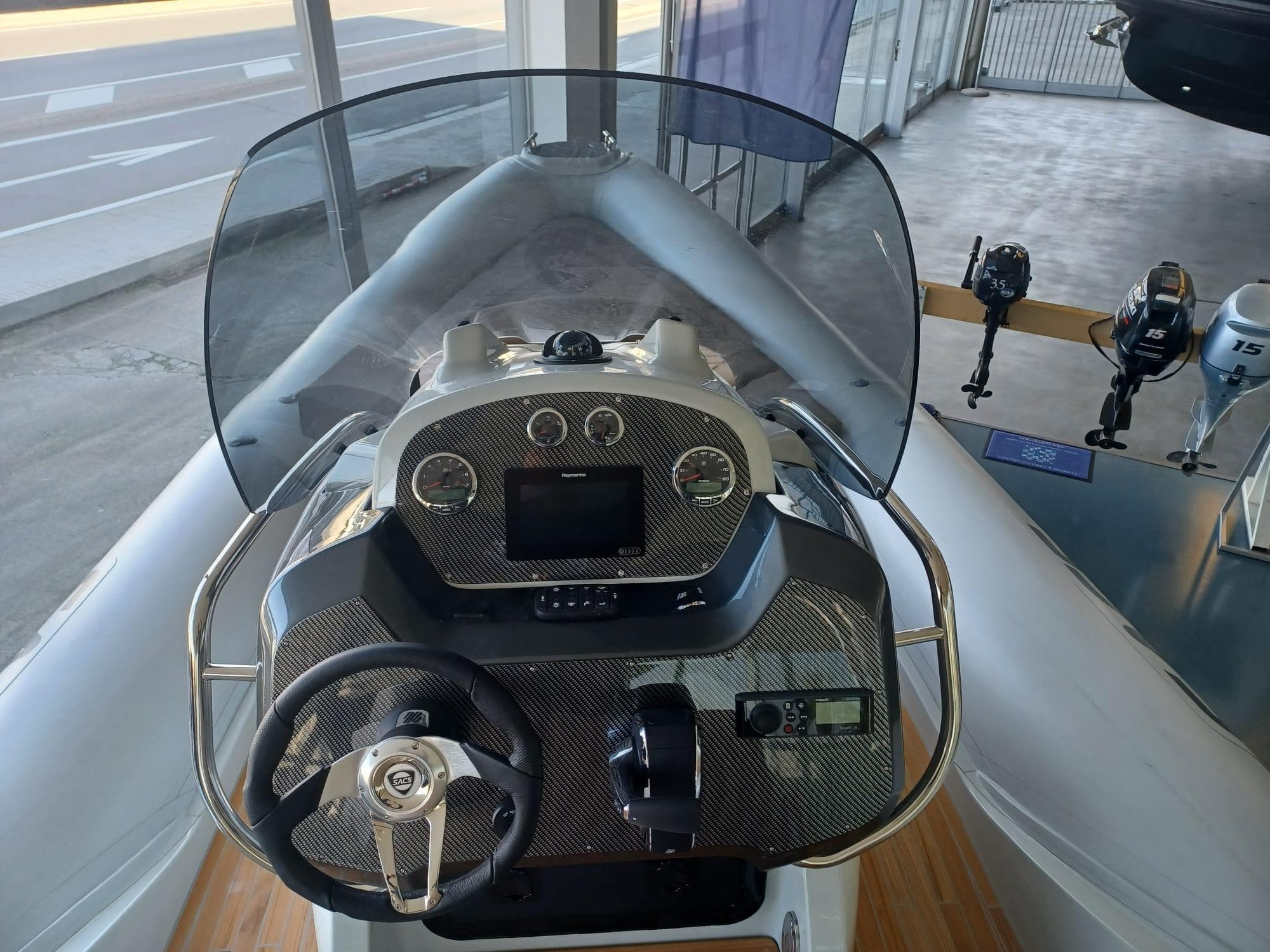 2025 SACS Strider 800 boat dashboard with steering wheel and control panel.