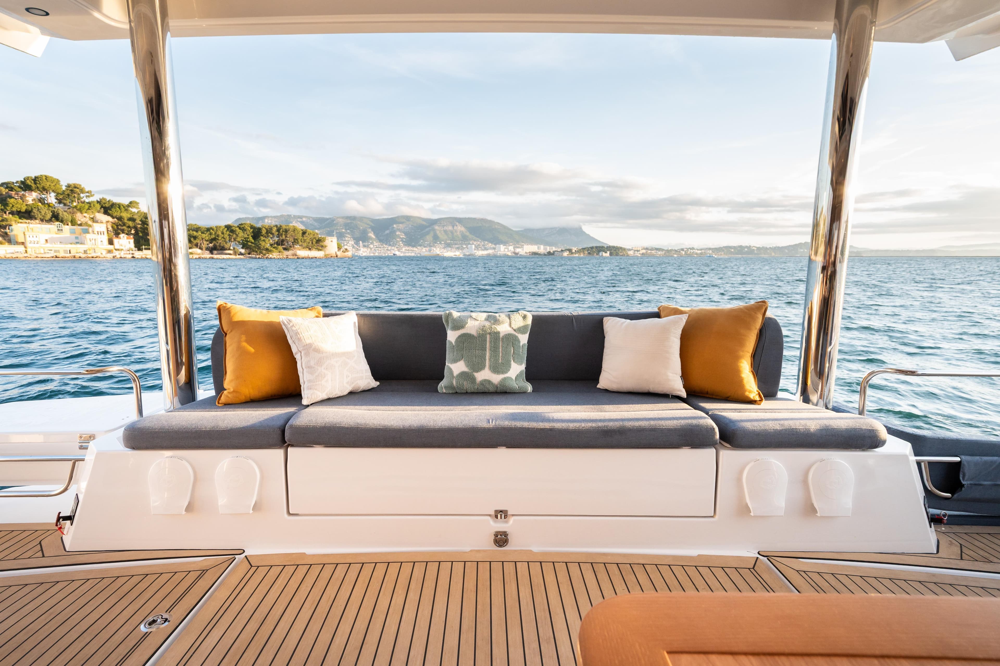 Luxurious Bali 5.2 yacht interior with plush seating, ocean view, and decorative cushions, 2026 model.