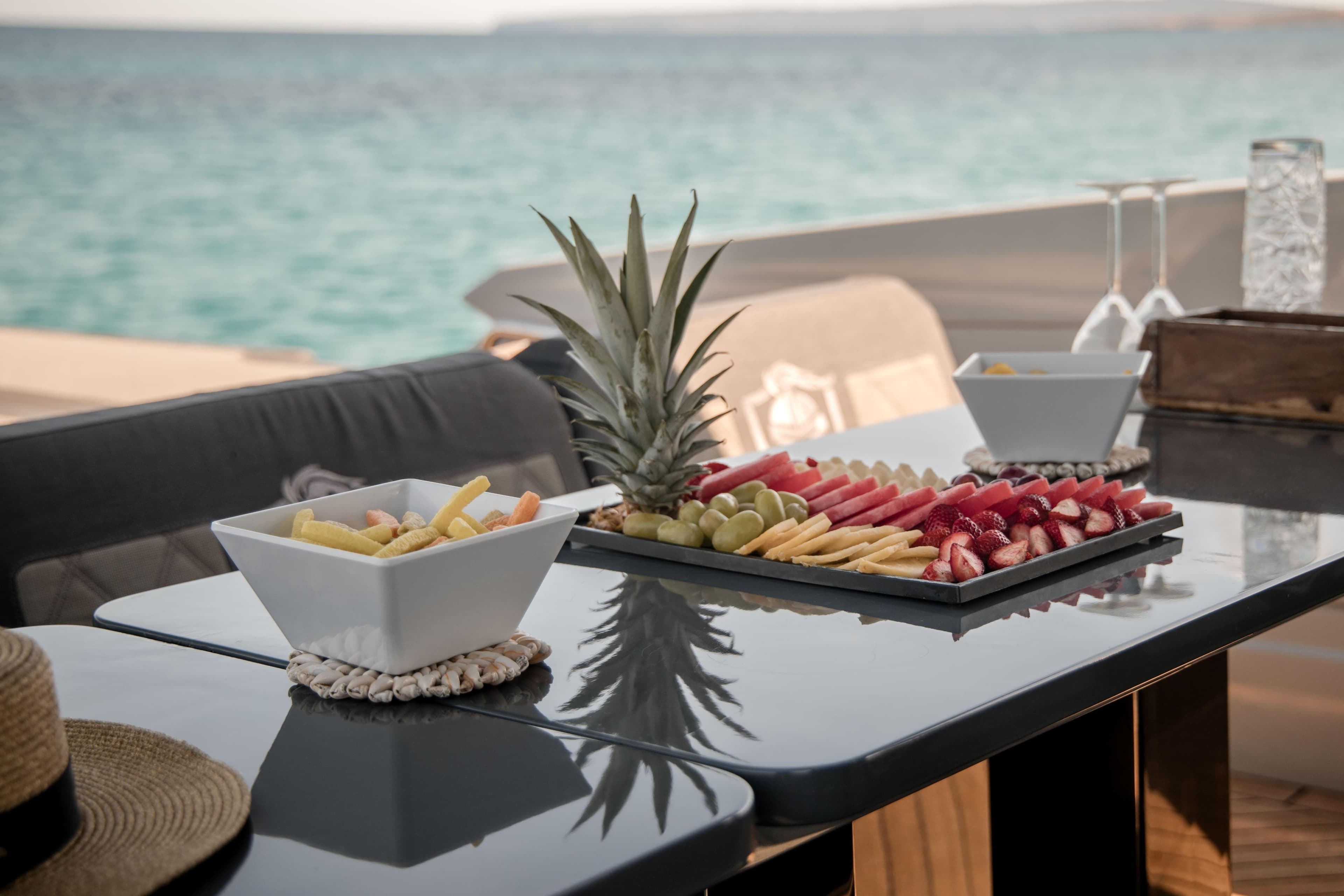 Luxurious Canados Gladiator 493 yacht dining setup with fruit platter, ocean view, 2022 model.