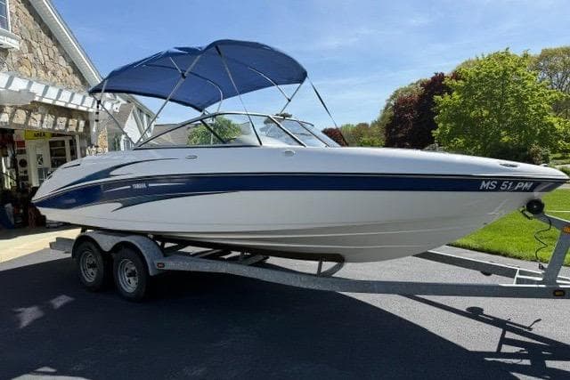 2004 Yamaha Boats SX230 on trailer with blue canopy, parked outdoors.