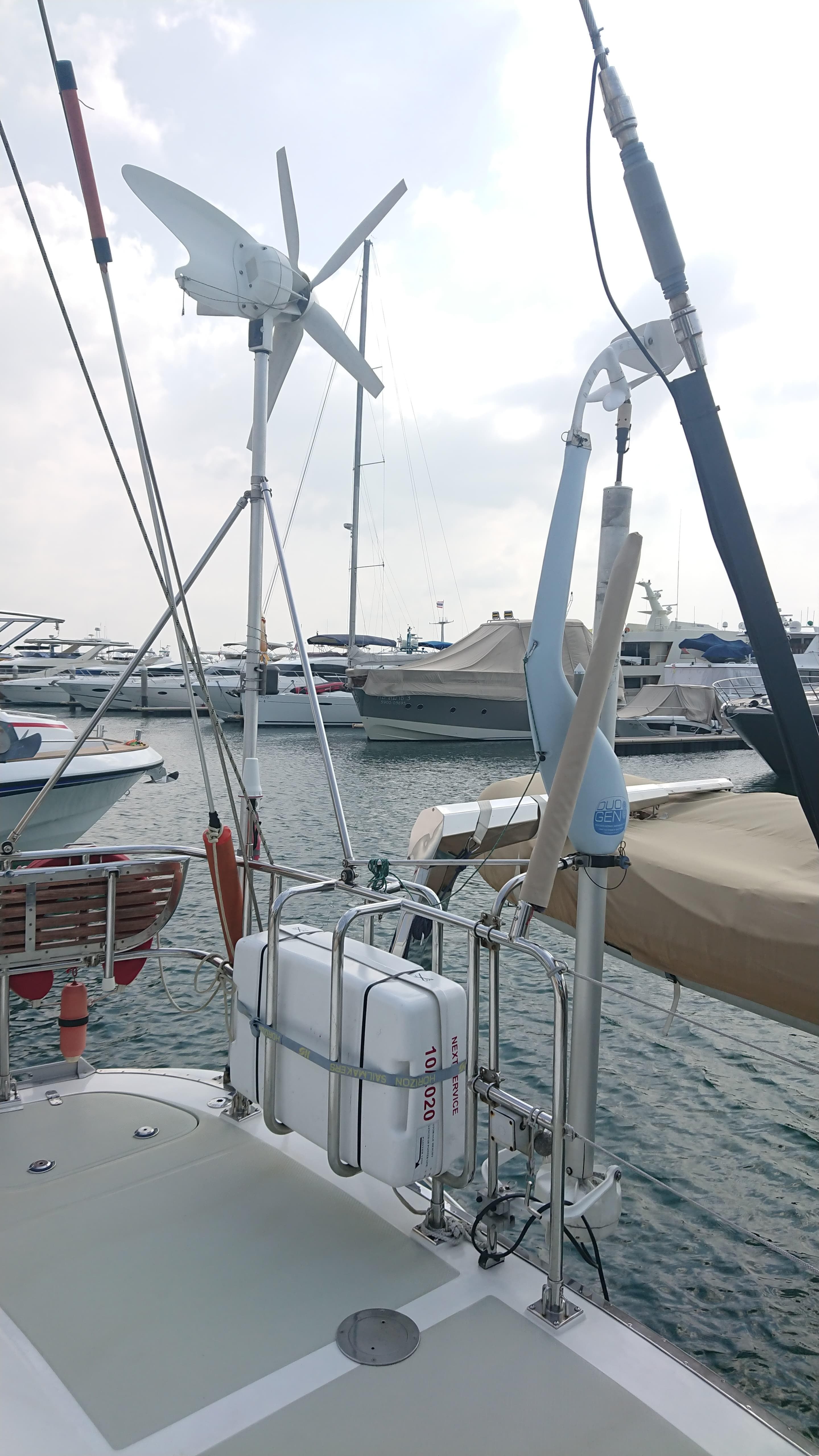 Sailboat docked at marina, featuring wind turbine and solar panels, Hylas H54, 2004 model.