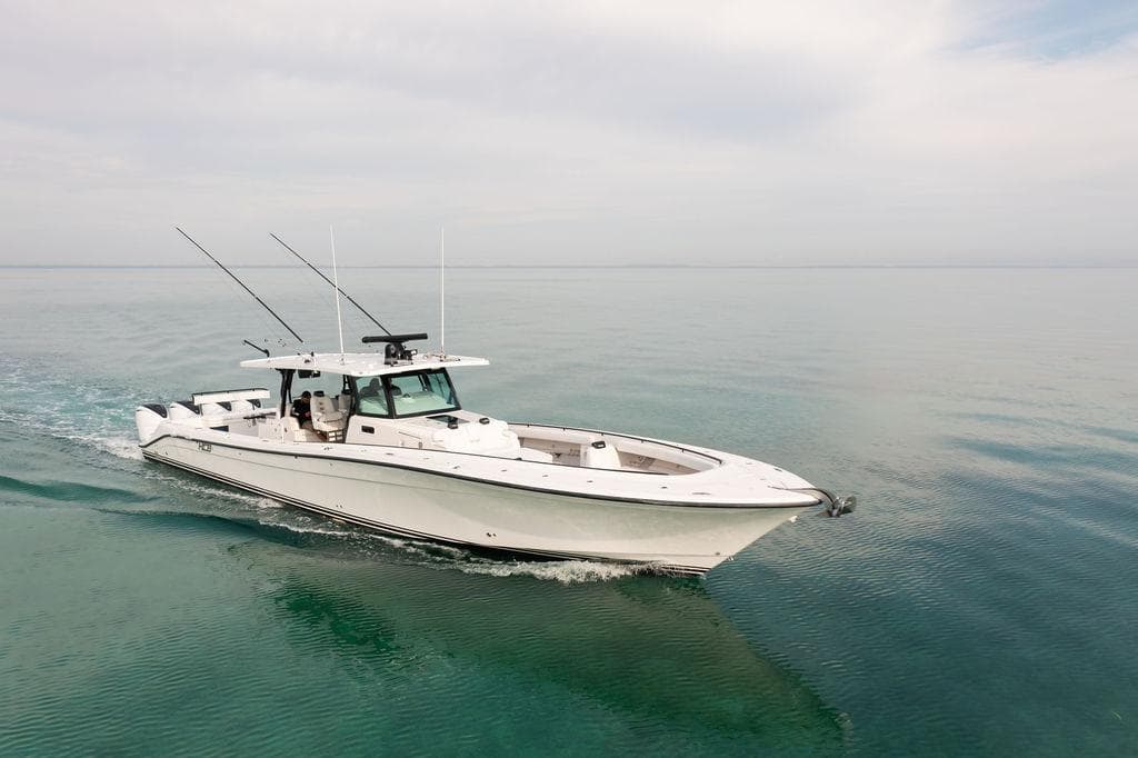 2019 HCB 53 boat cruising on calm, clear waters under a cloudy sky.