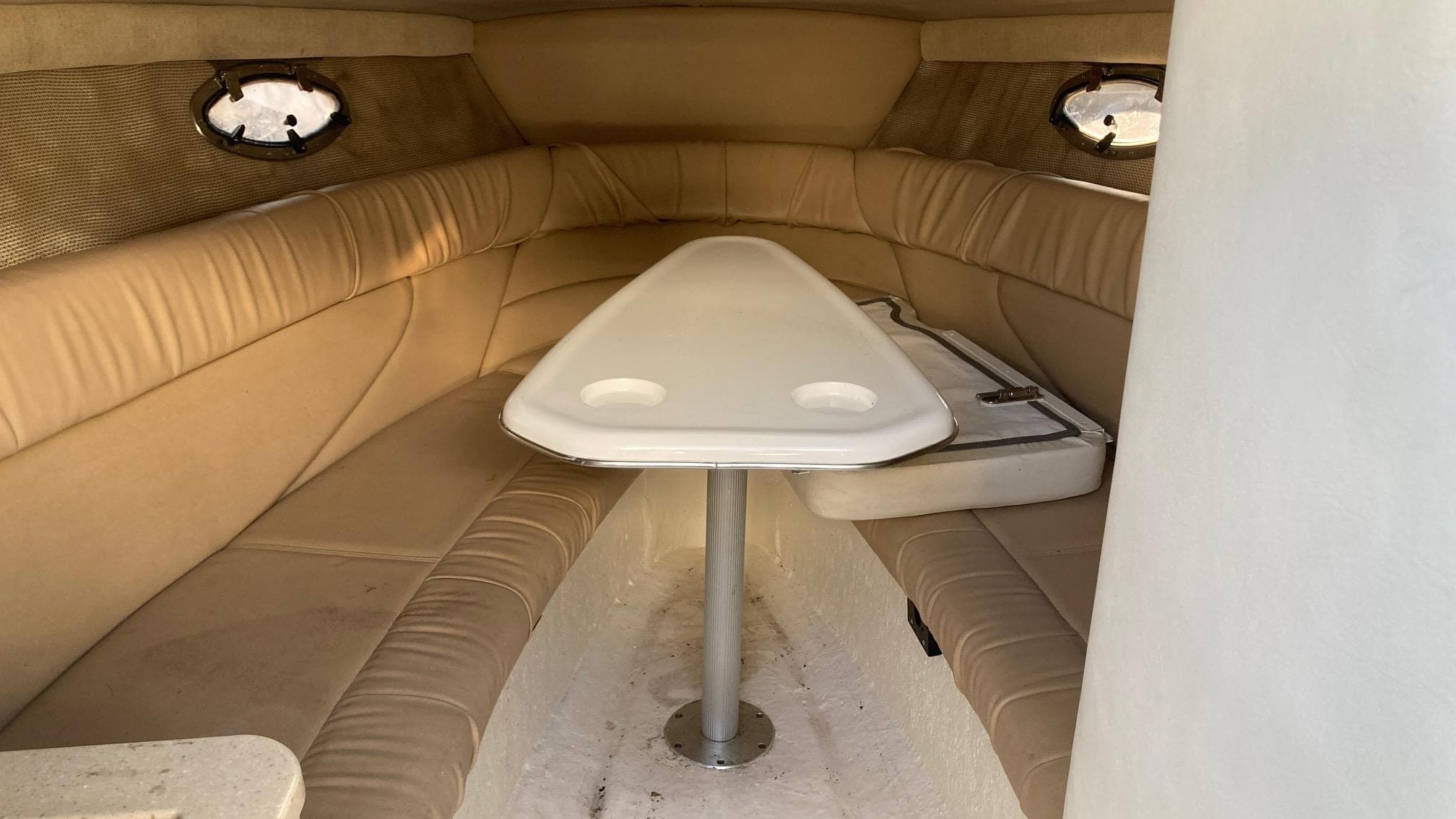 Interior cabin of a 2006 Cobalt 263 boat with beige seating and a white table.