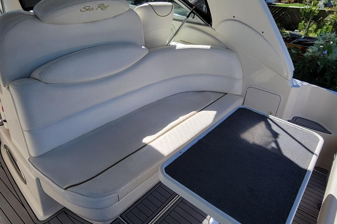 Interior seating of 1999 Sea Ray 340 Sundancer boat with table.