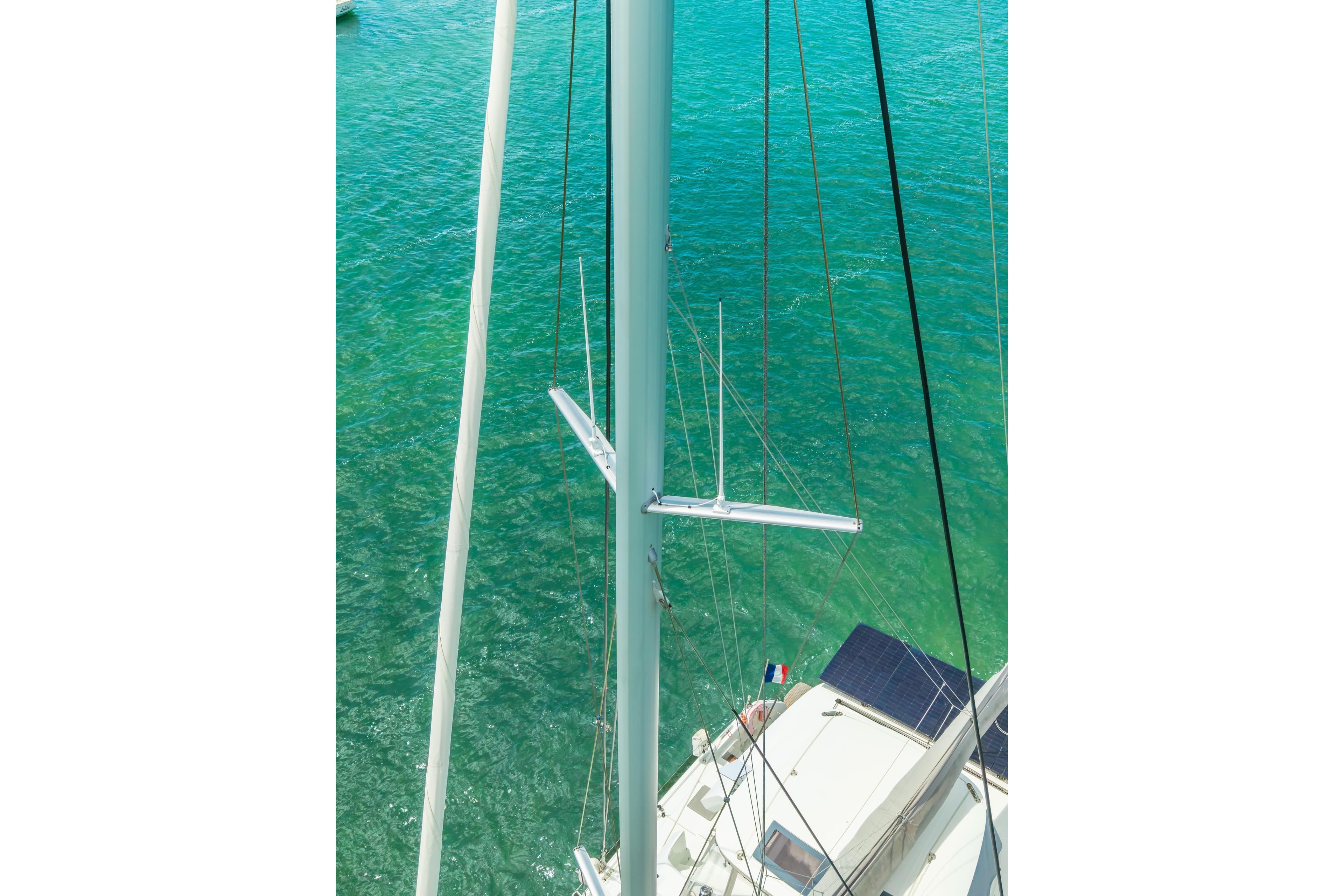 Aerial view of 2024 Lagoon 51 sailboat mast over turquoise water.