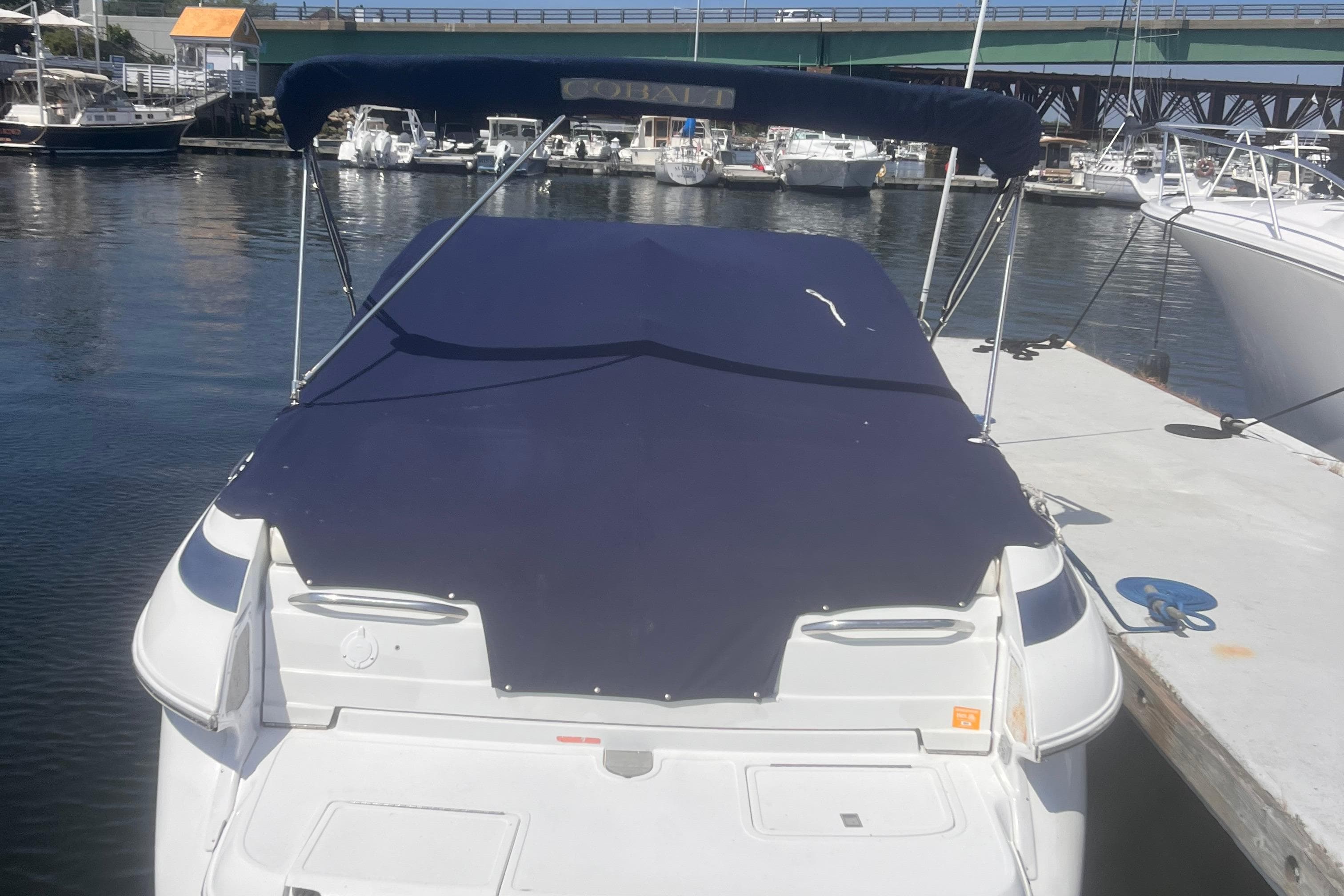 2003 Cobalt 263 boat docked at marina with blue cover.