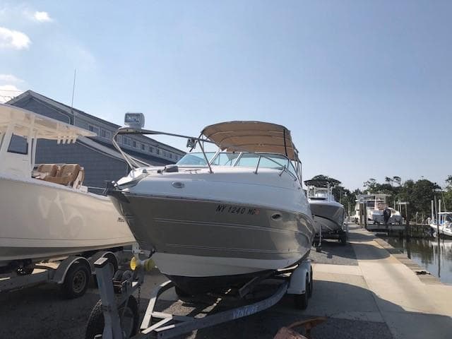 2008 Glastron GS 259 boat on trailer at marina.
