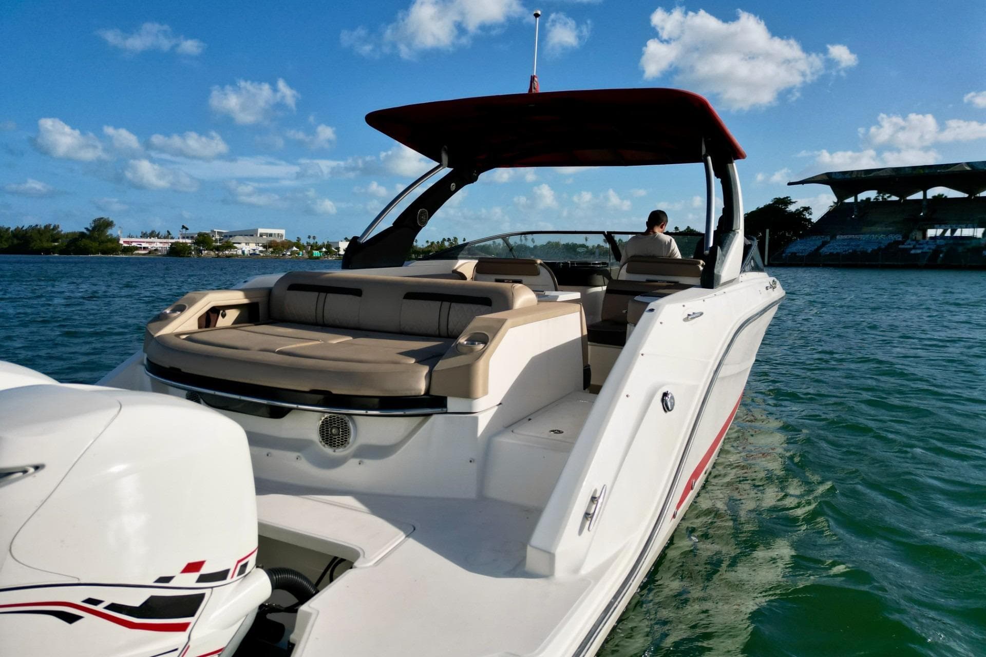 2017 Sea Ray SLX 310 Outboard cruising on a sunny day with clear blue skies.