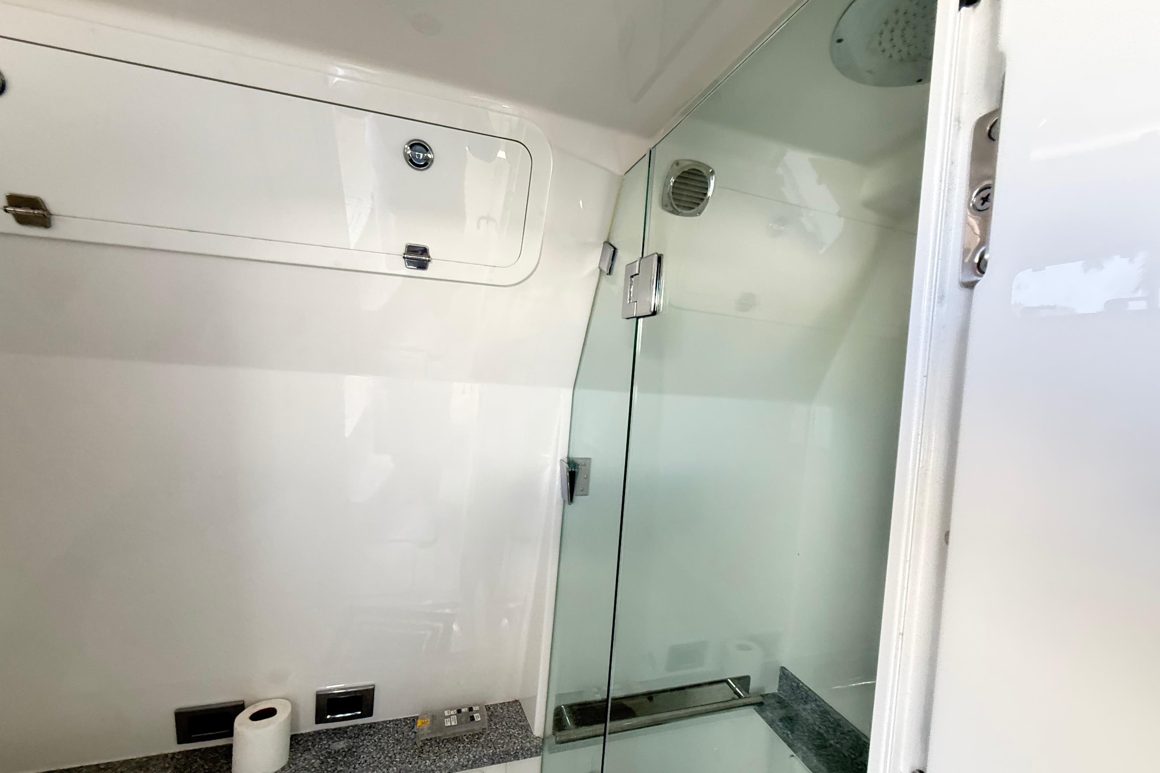 Interior of 2019 HCB 53 Suenos yacht bathroom with glass shower door.