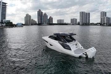 2025 NX Boats NX360 Sport Coupe on water with city skyline backdrop.