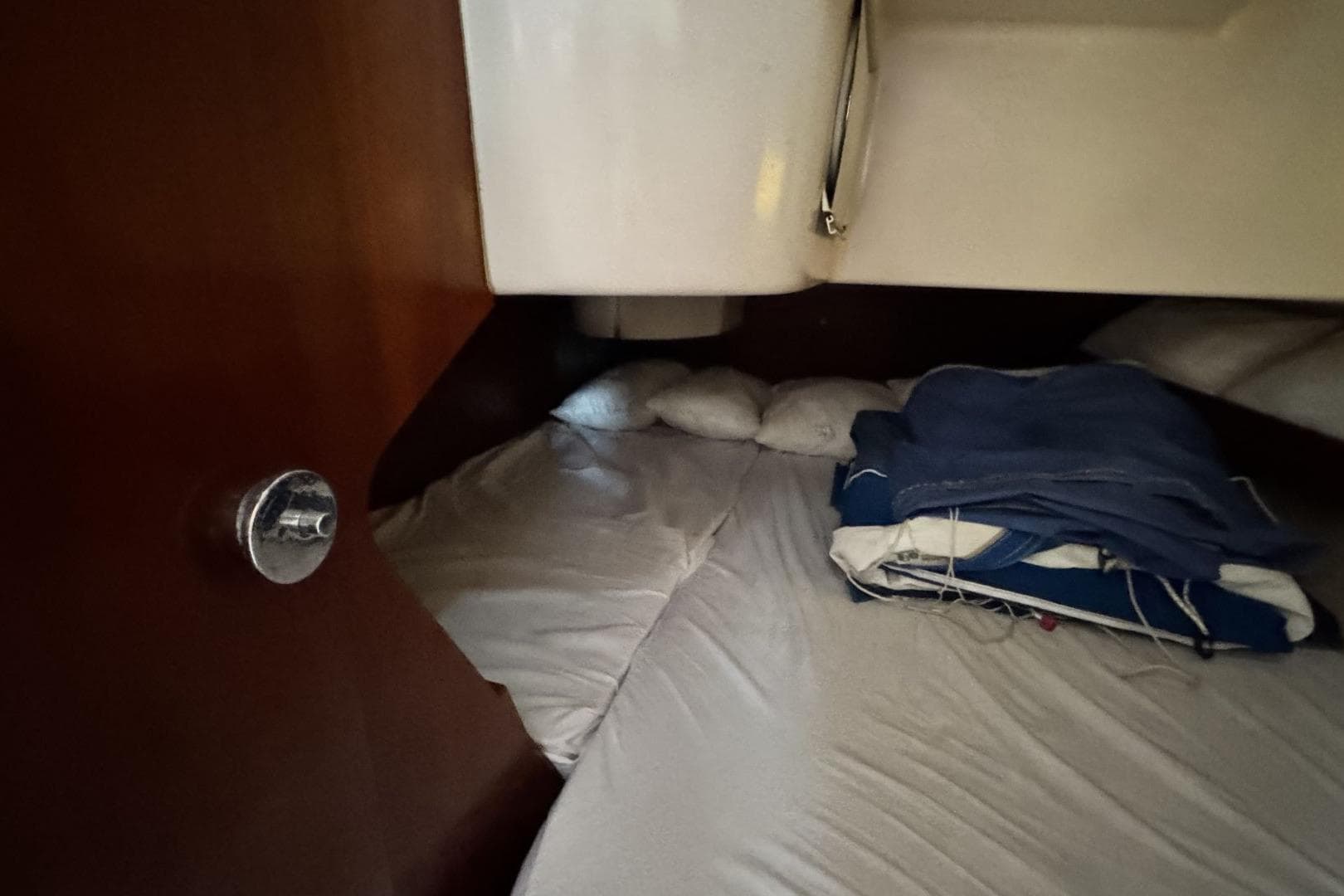 Cozy cabin interior of 1993 Beneteau Oceanis 351 sailboat with folded linens.