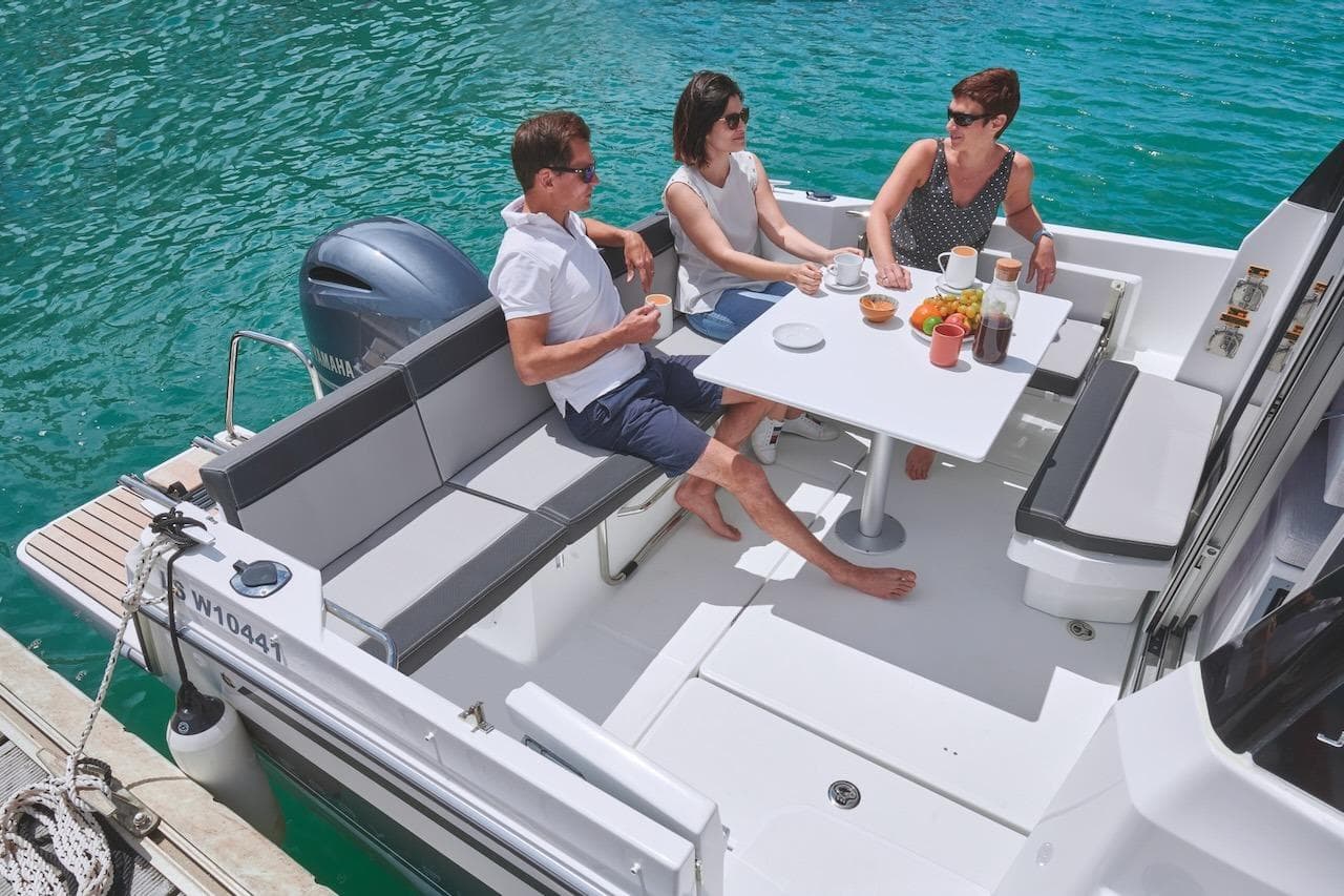 People enjoying a meal on a 2025 Jeanneau NC 795 Series 2 boat.