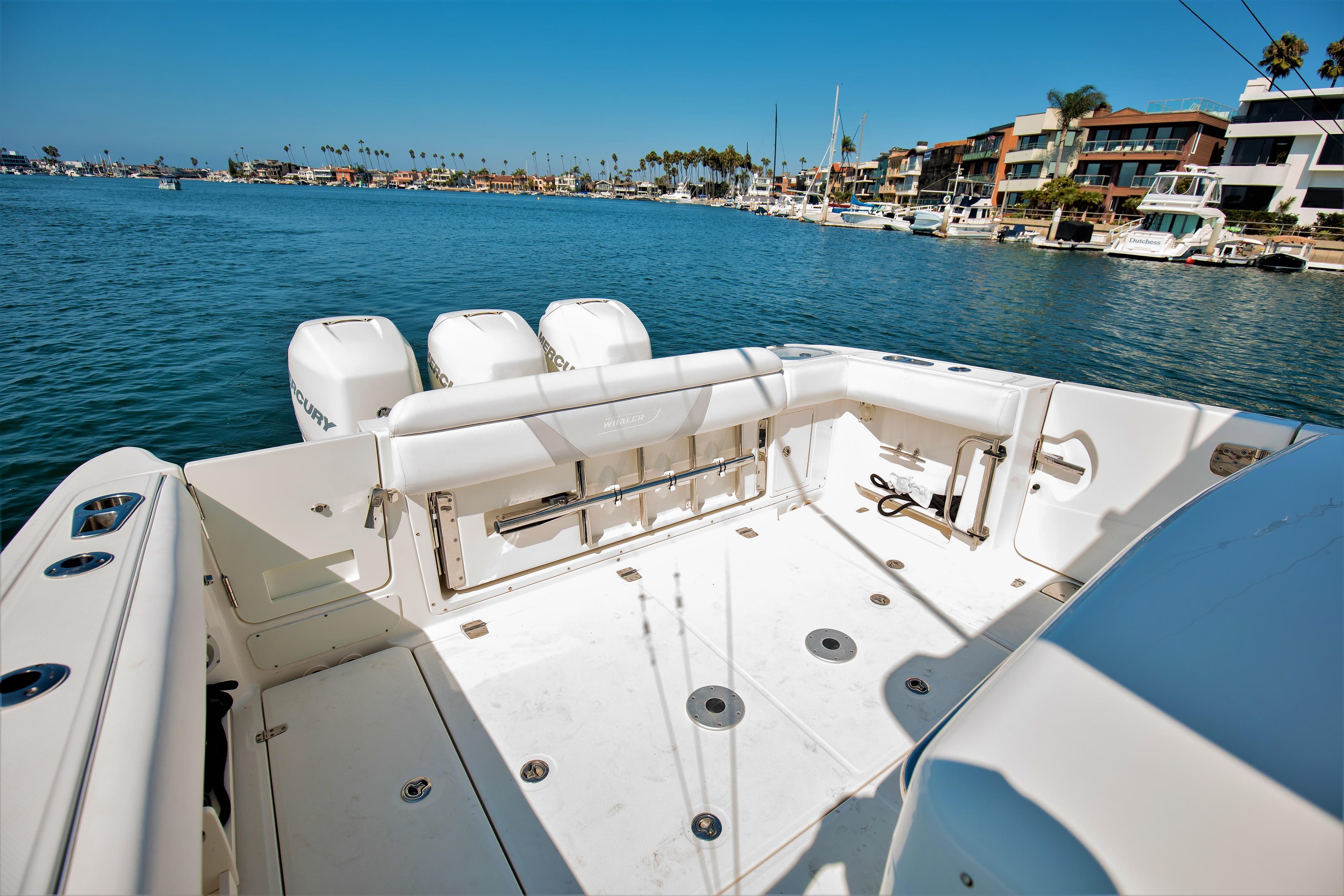 2014 Boston Whaler 370 Outrage boat with spacious deck, docked in a scenic marina.