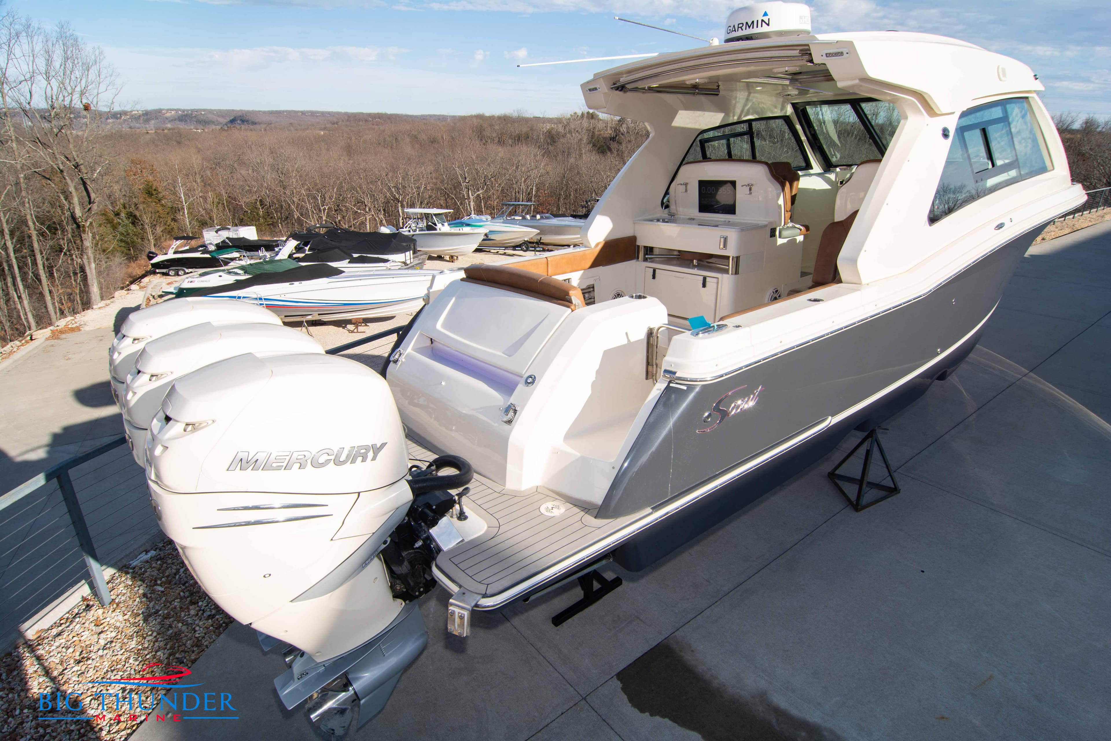 2022 Scout 350 LXZ boat with triple Mercury engines, docked outdoors.
