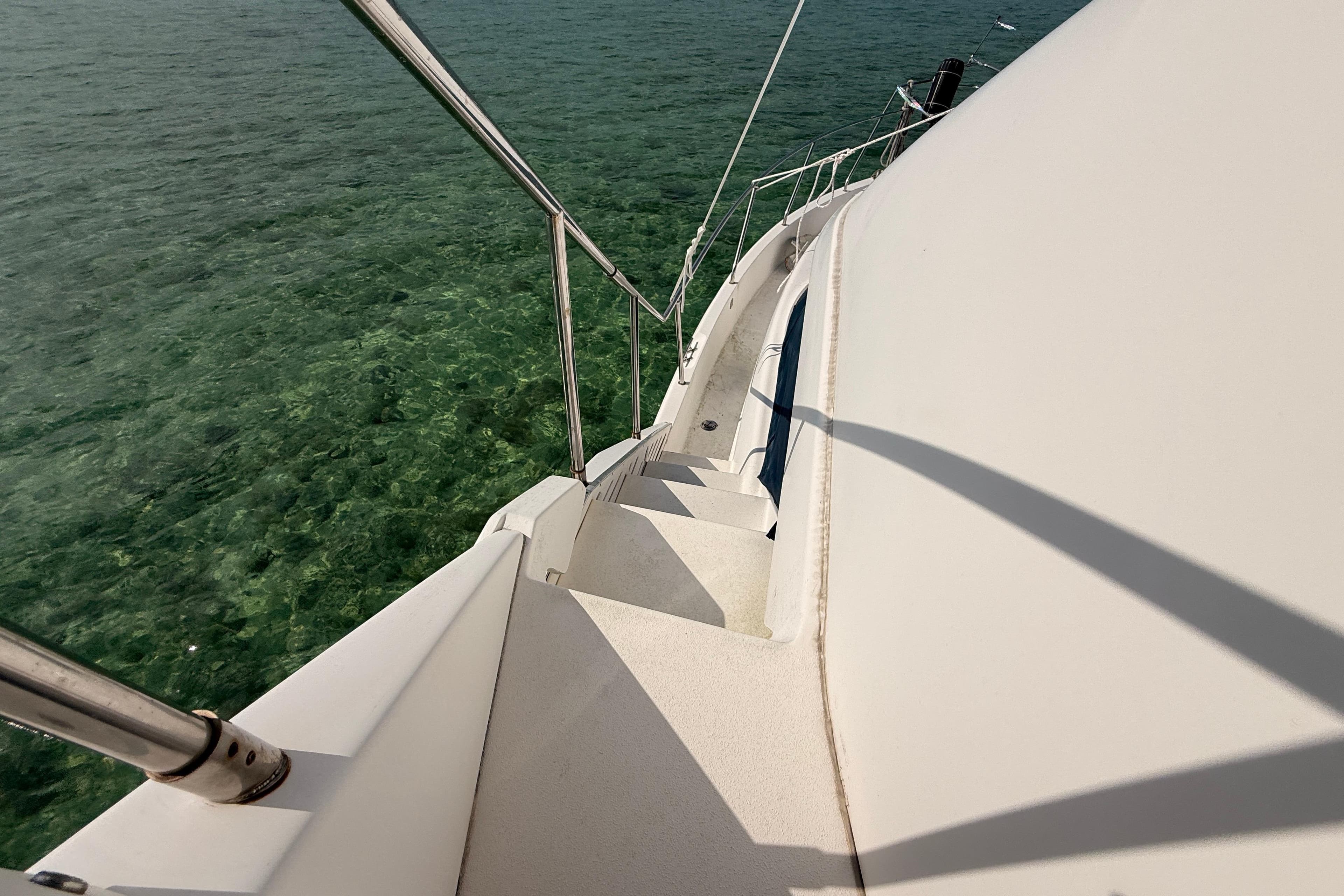1998 Silverton 40 Convertible yacht deck overlooking clear green water.