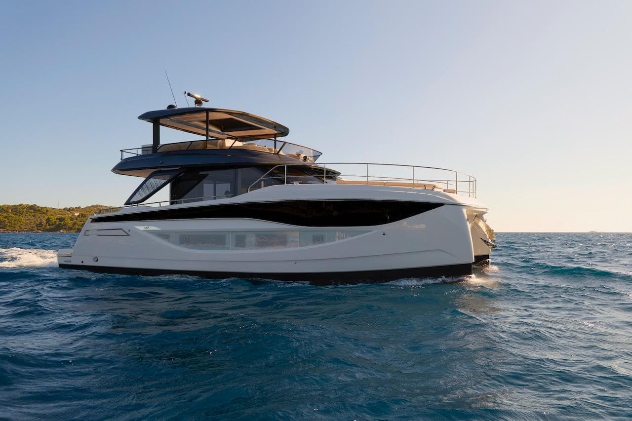 Luxurious 2025 Prestige M7 yacht cruising on open sea under clear sky.