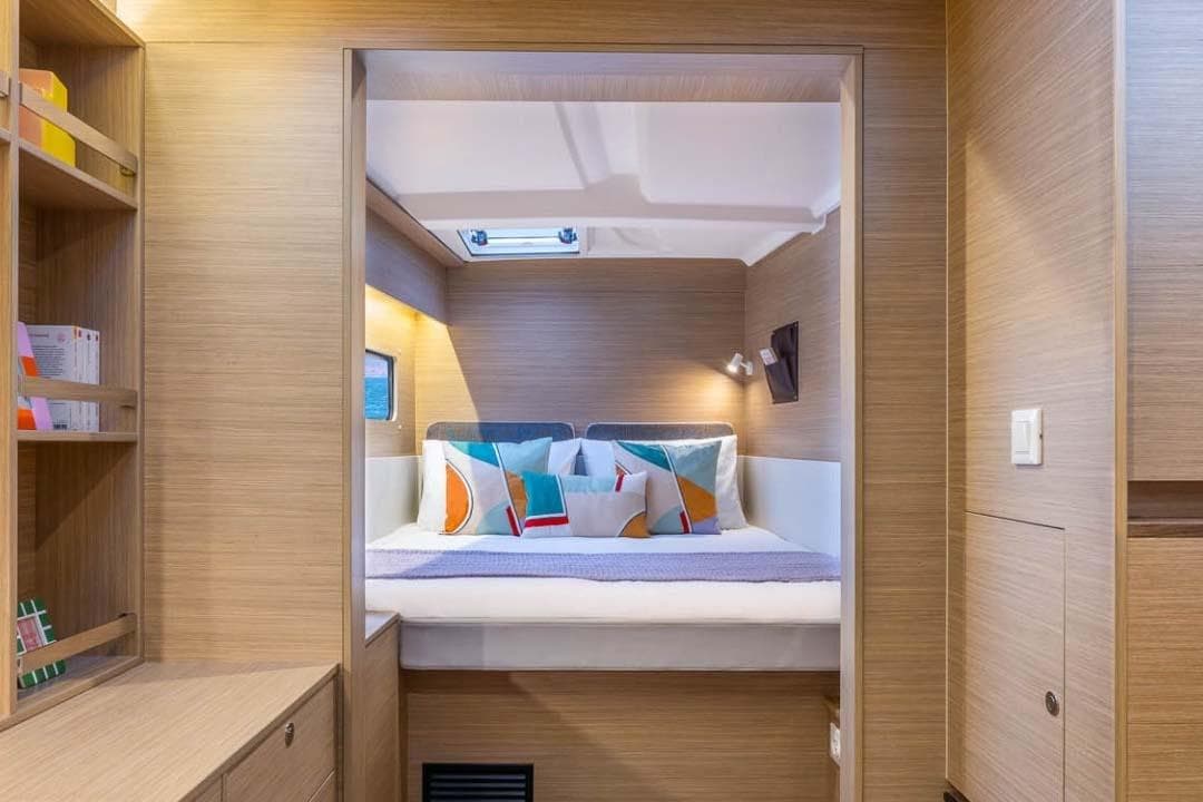 Manufacturer Provided Image: Luxurious interior cabin of 2026 Lagoon 38 yacht with modern design and colorful pillows.