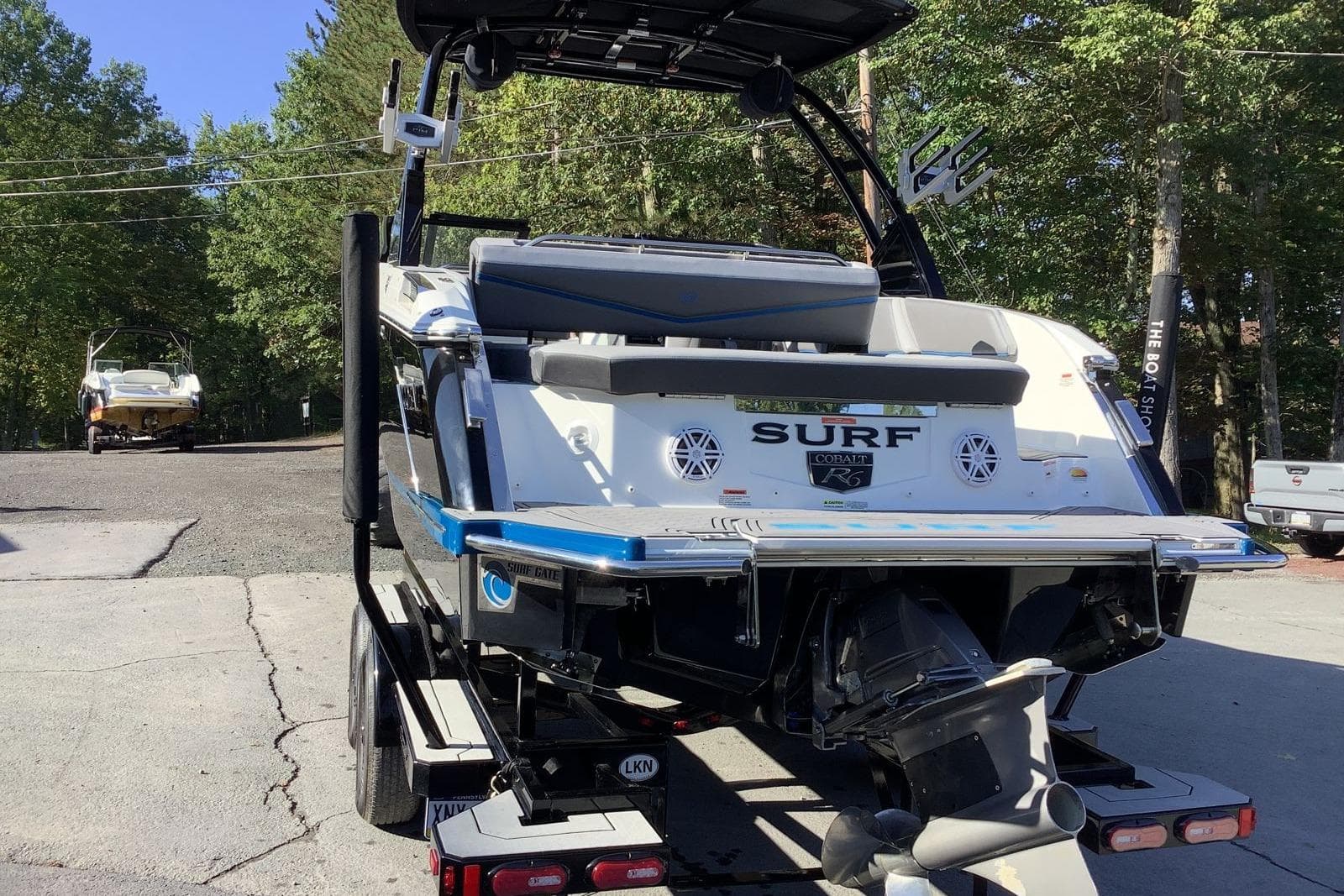 2022 Cobalt R6 Surf boat on trailer, rear view, in outdoor setting.