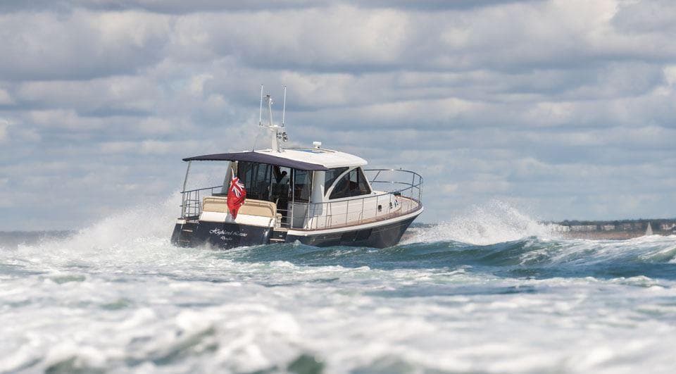 2010 Hunt Yachts 52 navigating through waves under a cloudy sky.