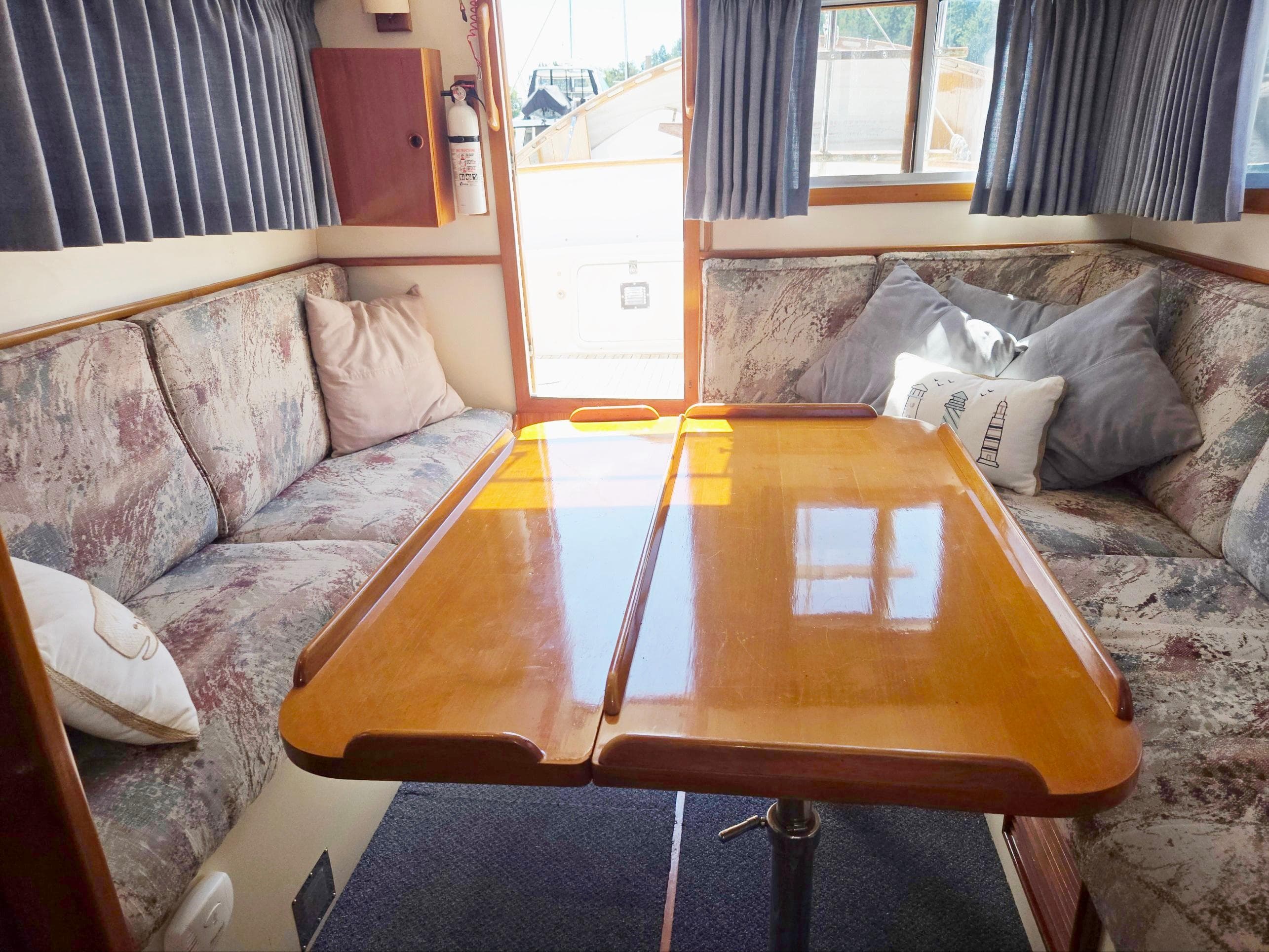 1989 Eagle Pilothouse interior with cozy seating and wooden table.