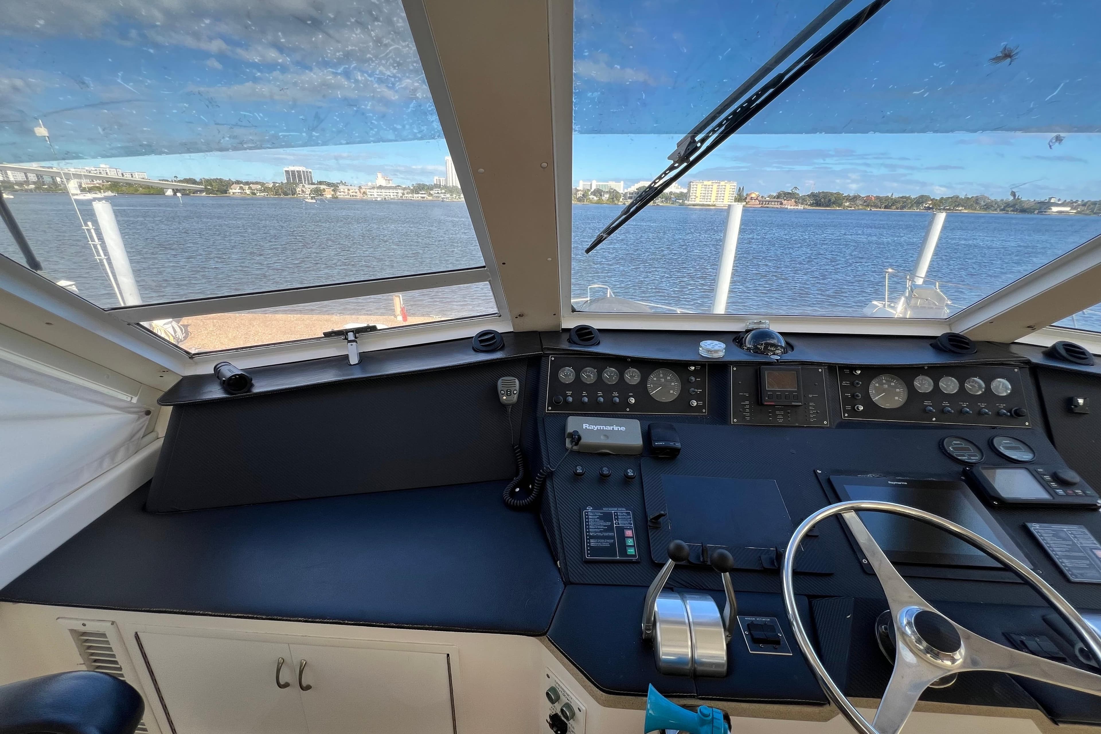Cockpit view of 1999 Viking 60 CPMY yacht with steering wheel and control panel.