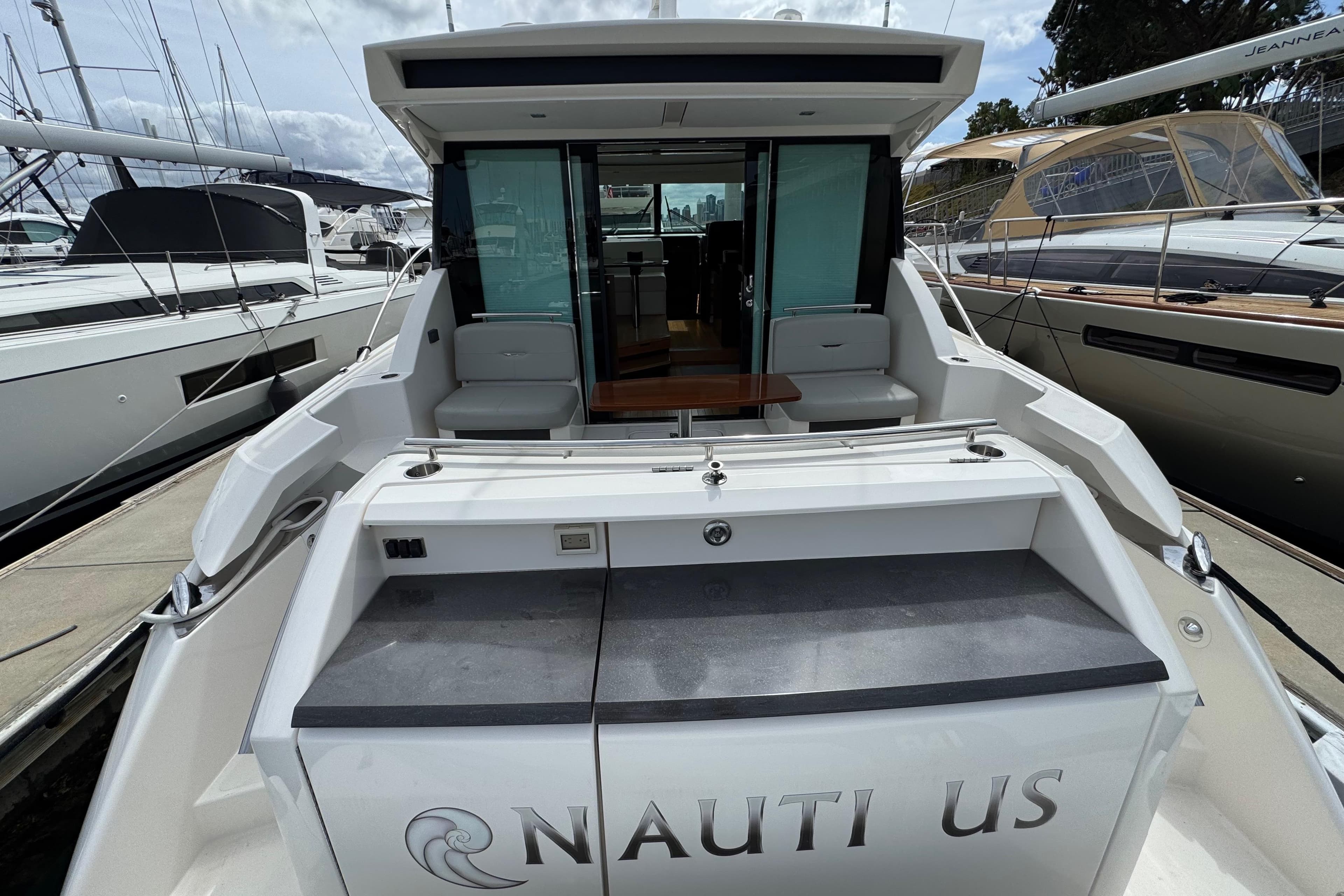 2018 Tiara Yachts C44 Coupe, rear view, docked with open cockpit and seating area.