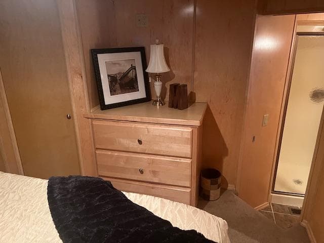 Cozy bedroom in a 2007 Thoroughbred houseboat with wooden furniture and a small lamp.
