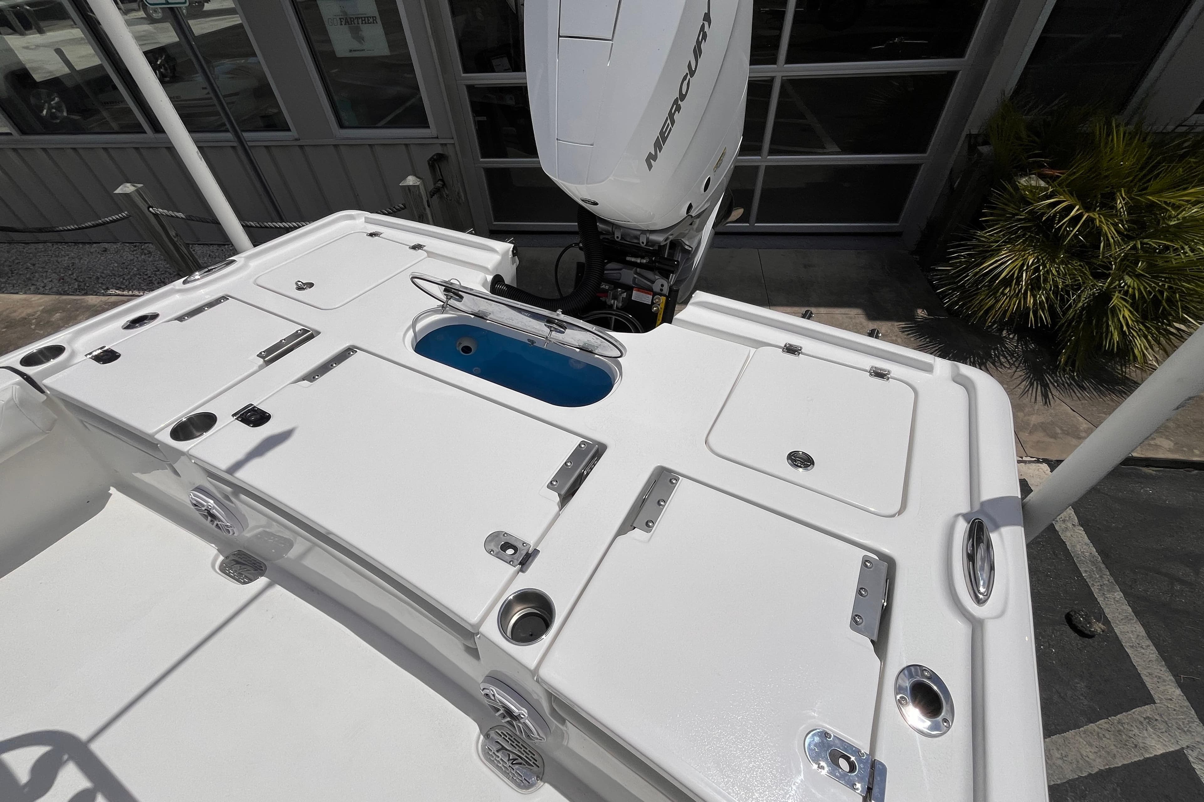2026 Tidewater 2500 Carolina Bay boat deck with Mercury engine, featuring storage compartments.