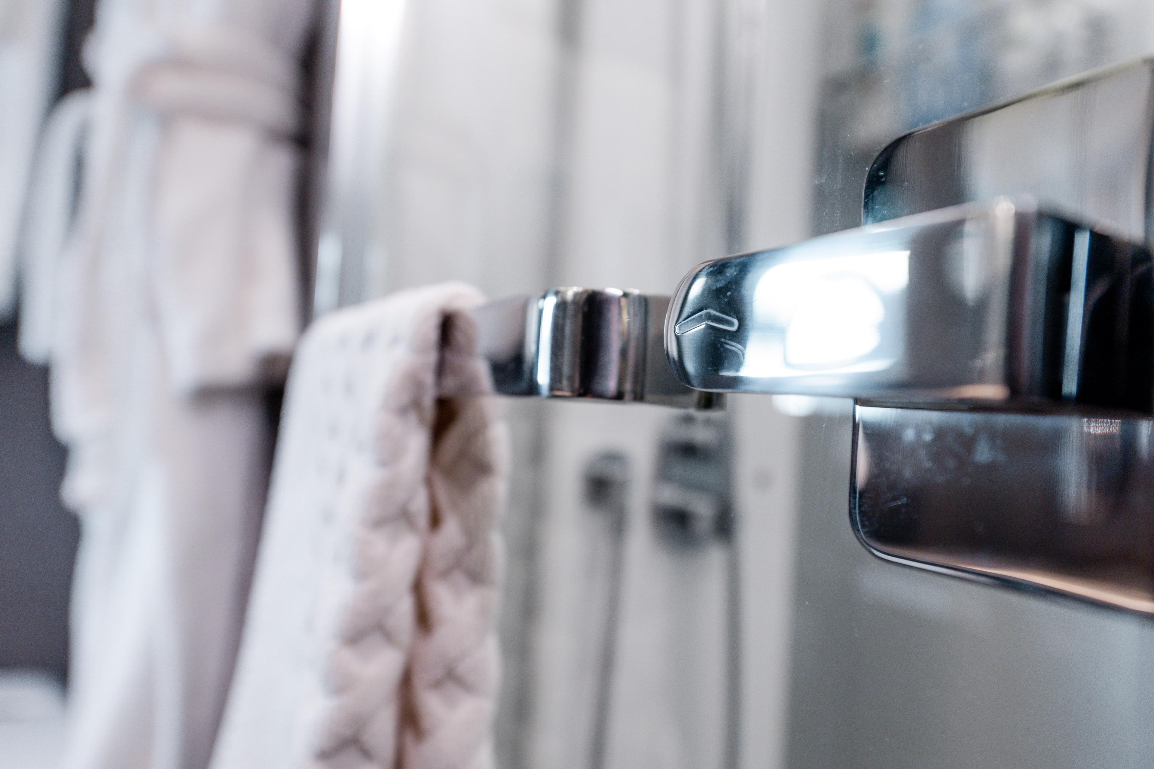 Close-up of a chrome handle and towel in Azimut S8 yacht bathroom, 2020 model.